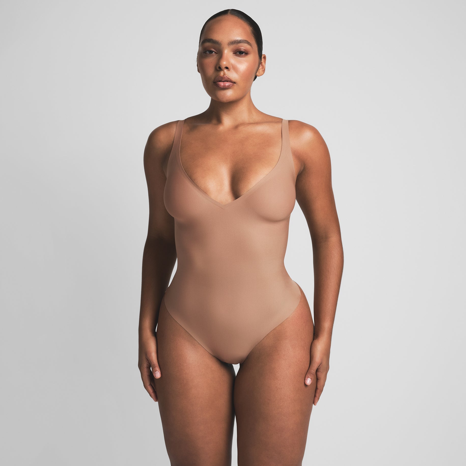 SKIMS BODY UNLINED PLUNGE THONG BODYSUIT | SIENNA ON A MODEL FRONT VIEW