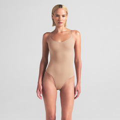 SHEER SEAMLESS THONG BODYSUIT | CLAY ON A MODEL FRONT VIEW
