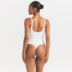 SKIMS BODY UNLINED PLUNGE THONG BODYSUIT | IVORY ON A MODEL SIDE VIEW @