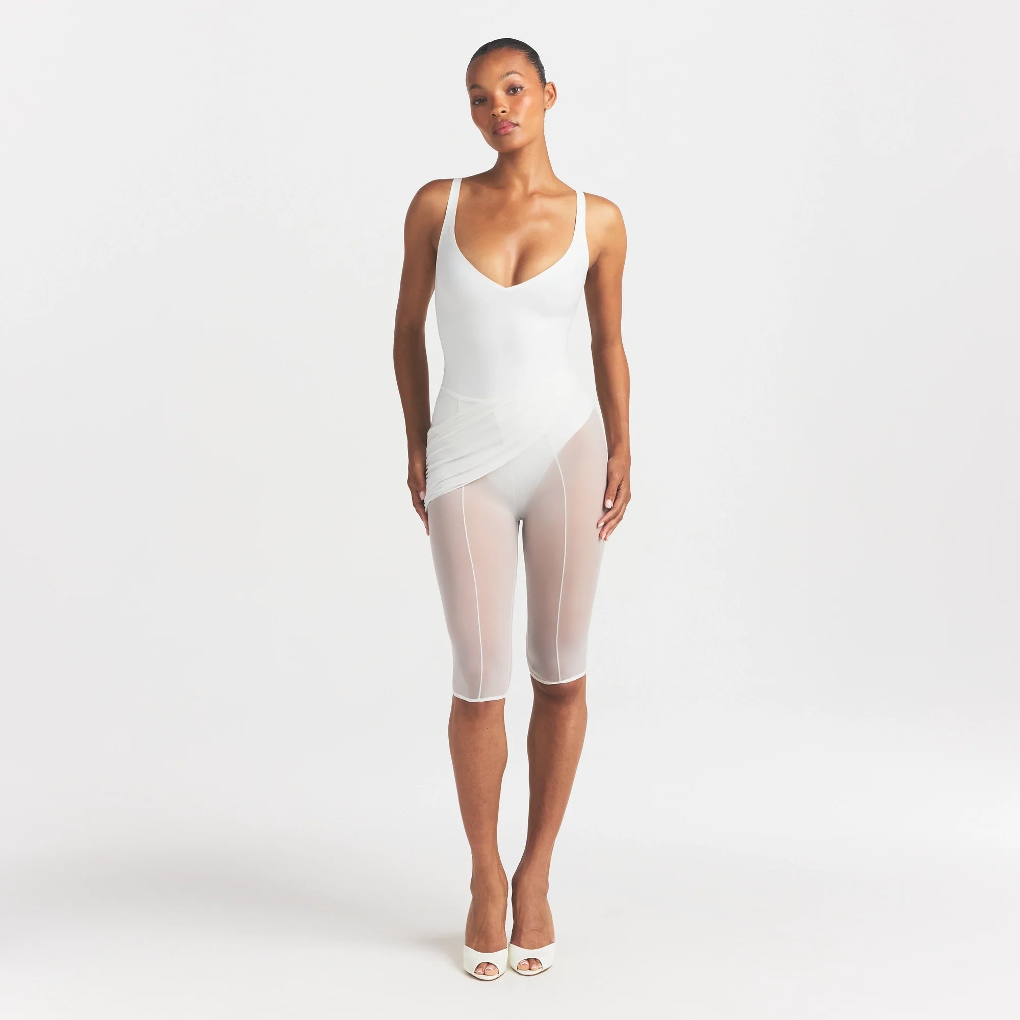 SKIMS BODY UNLINED PLUNGE THONG BODYSUIT | IVORY ON A MODEL FRONT VIEW @