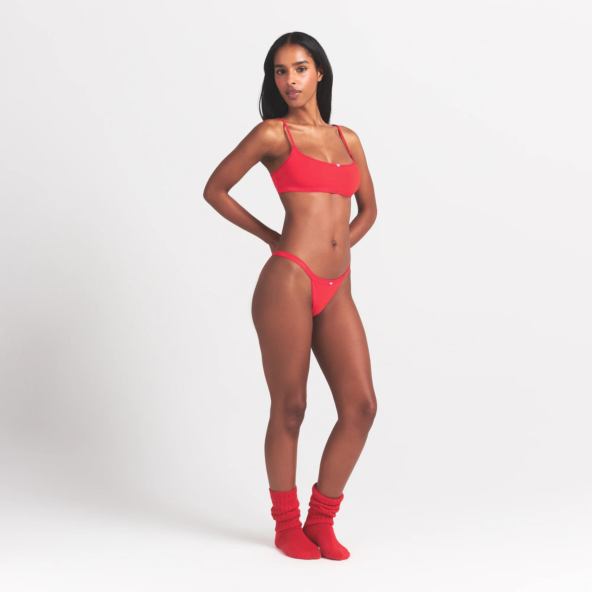LIGHTWEIGHT COTTON LOGO PICOT STRING BIKINI | RUBY TONAL ON A MODEL SIDE VIEW @ | FOCUS: 0.0, 1.0, 0.9