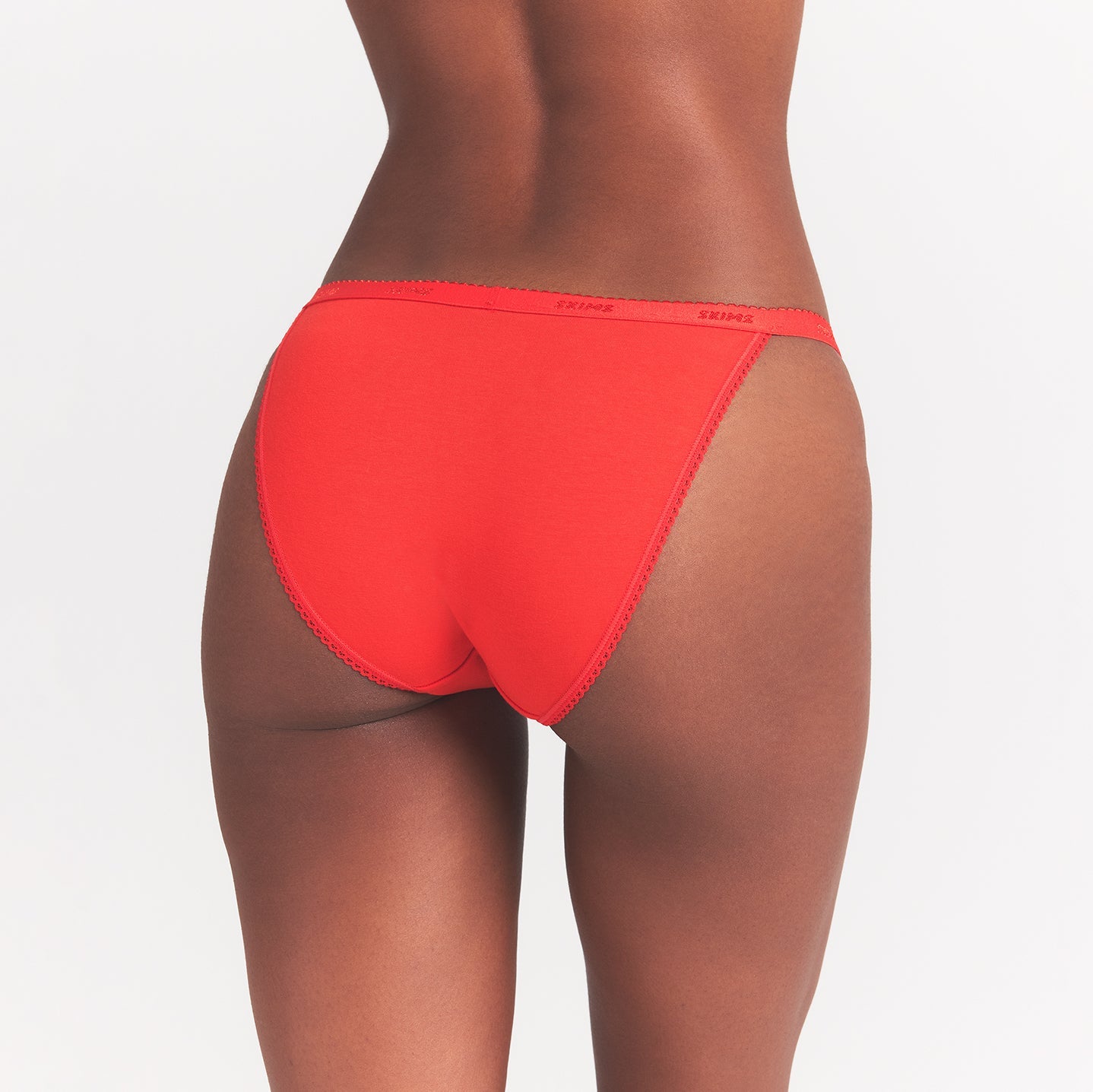LIGHTWEIGHT COTTON LOGO PICOT STRING BIKINI | RUBY TONAL ON A MODEL BACK VIEW @ | FOCUS: 0.0, 1.0, 0.9
