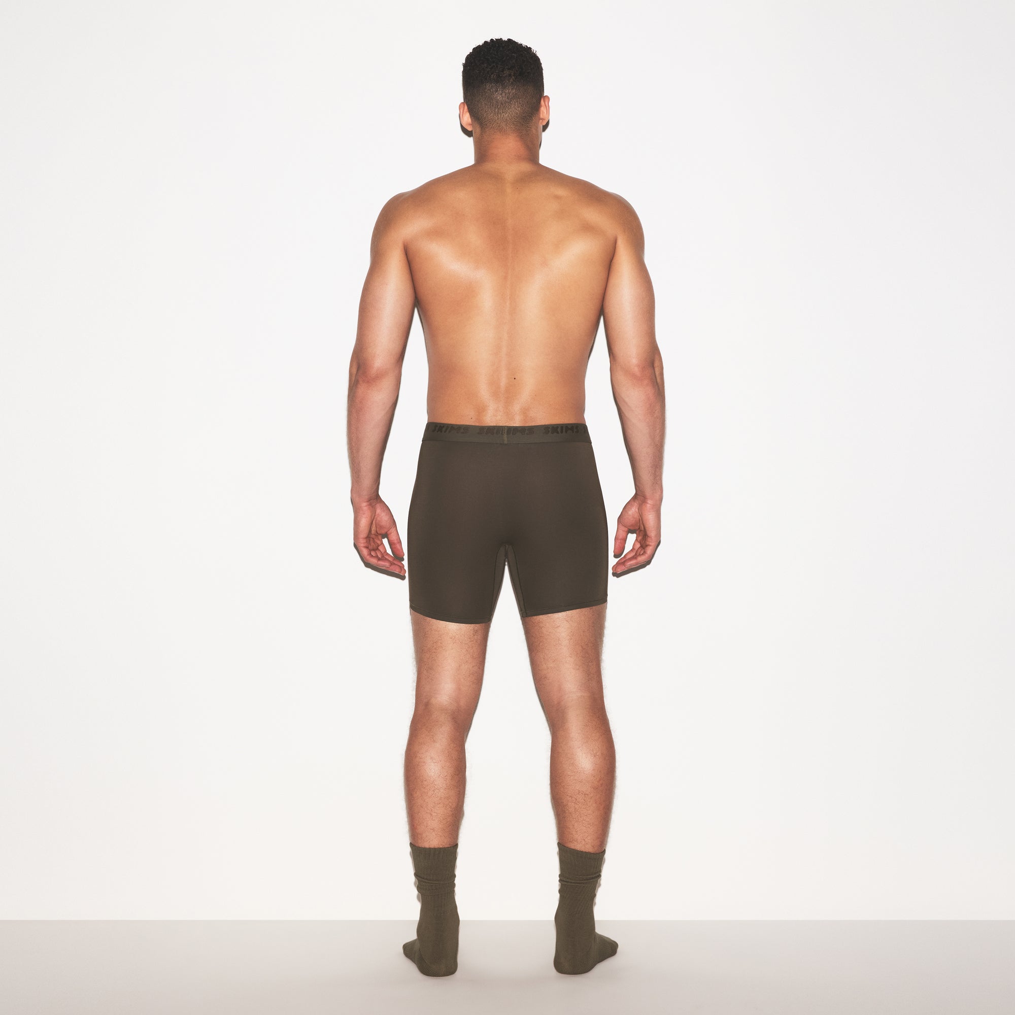 SKIMS STRETCH MENS 5 INCH BOXER BRIEF | LODEN ON A MODEL FRONT VIEW @ | FOCUS: 0.0, 1.0, 0.9