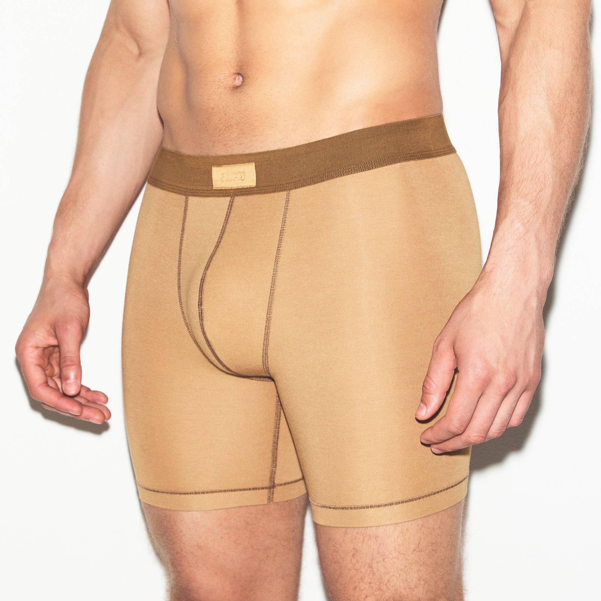SKIMS COTTON MENS 5 INCH BOXER BRIEF | RUSSET ON A MODEL SIDE VIEW | FOCUS: 0.0, 1.0, 0.9