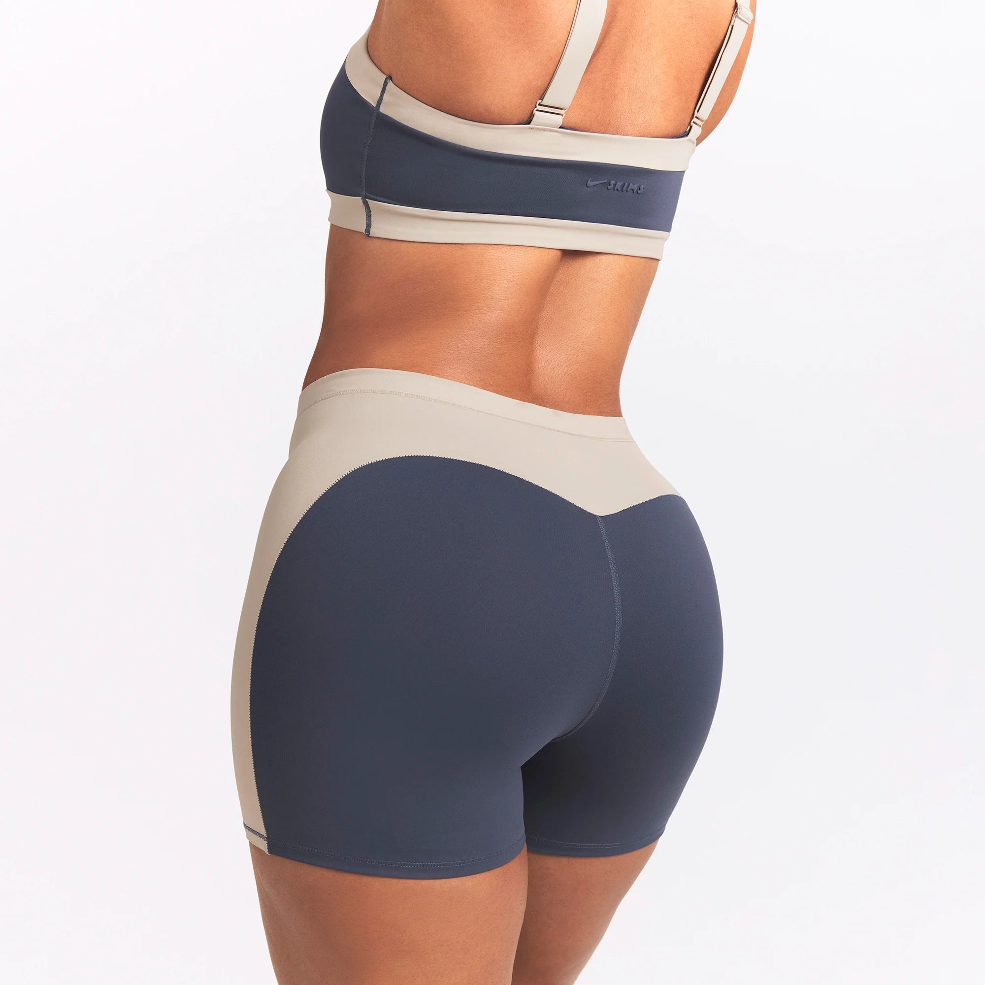 NikeSKIMS MATTE AND SHINE 5" BIKER SHORT | DEEP ROYAL/STONE ON A MODEL SIDE VIEW @ | FOCUS: 0.0, 1.0, 0.9