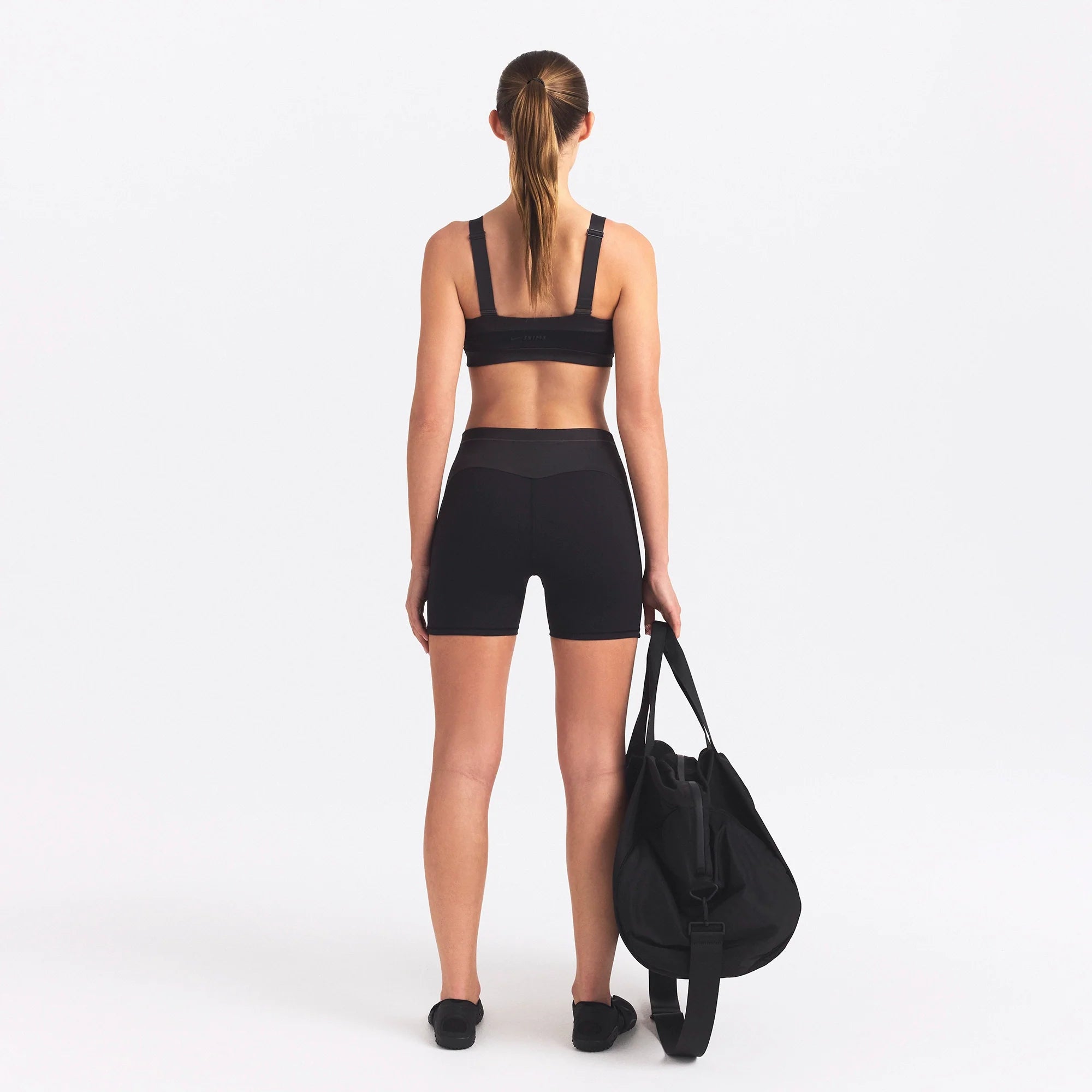 NikeSKIMS MATTE AND SHINE 5" BIKER SHORT | OBSIDIAN/IGNEOUS ON A MODEL SIDE VIEW @ | FOCUS: 0.0, 1.0, 0.9