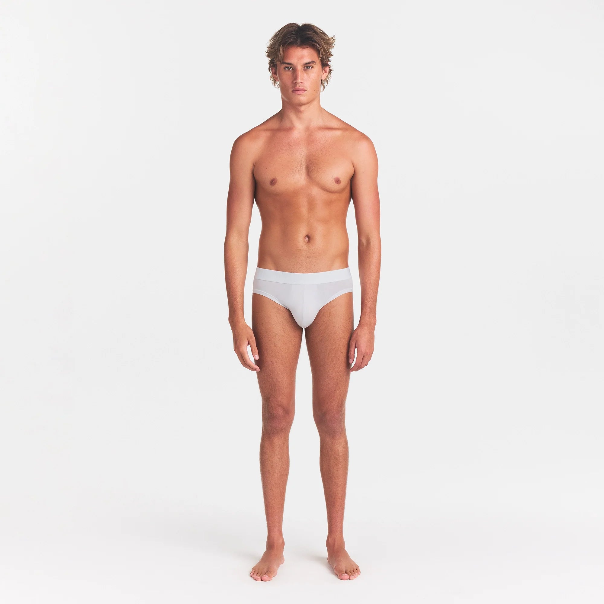 SKIMS STRETCH MENS BRIEF | CHALK ON A MODEL FRONT VIEW @ | FOCUS: 0.0, 1.0, 0.9