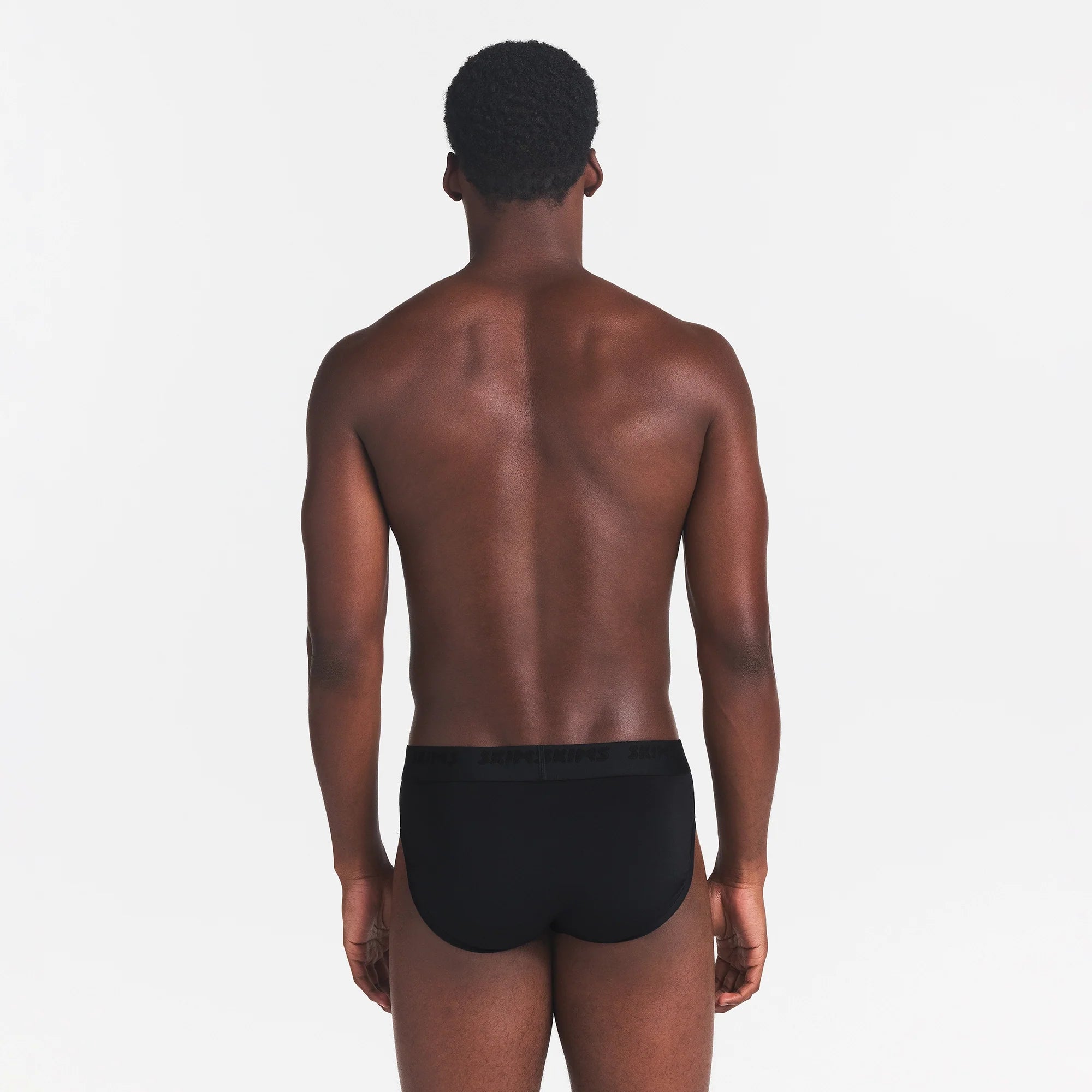 SKIMS STRETCH MENS BRIEF | OBSIDIAN ON A MODEL BACK VIEW