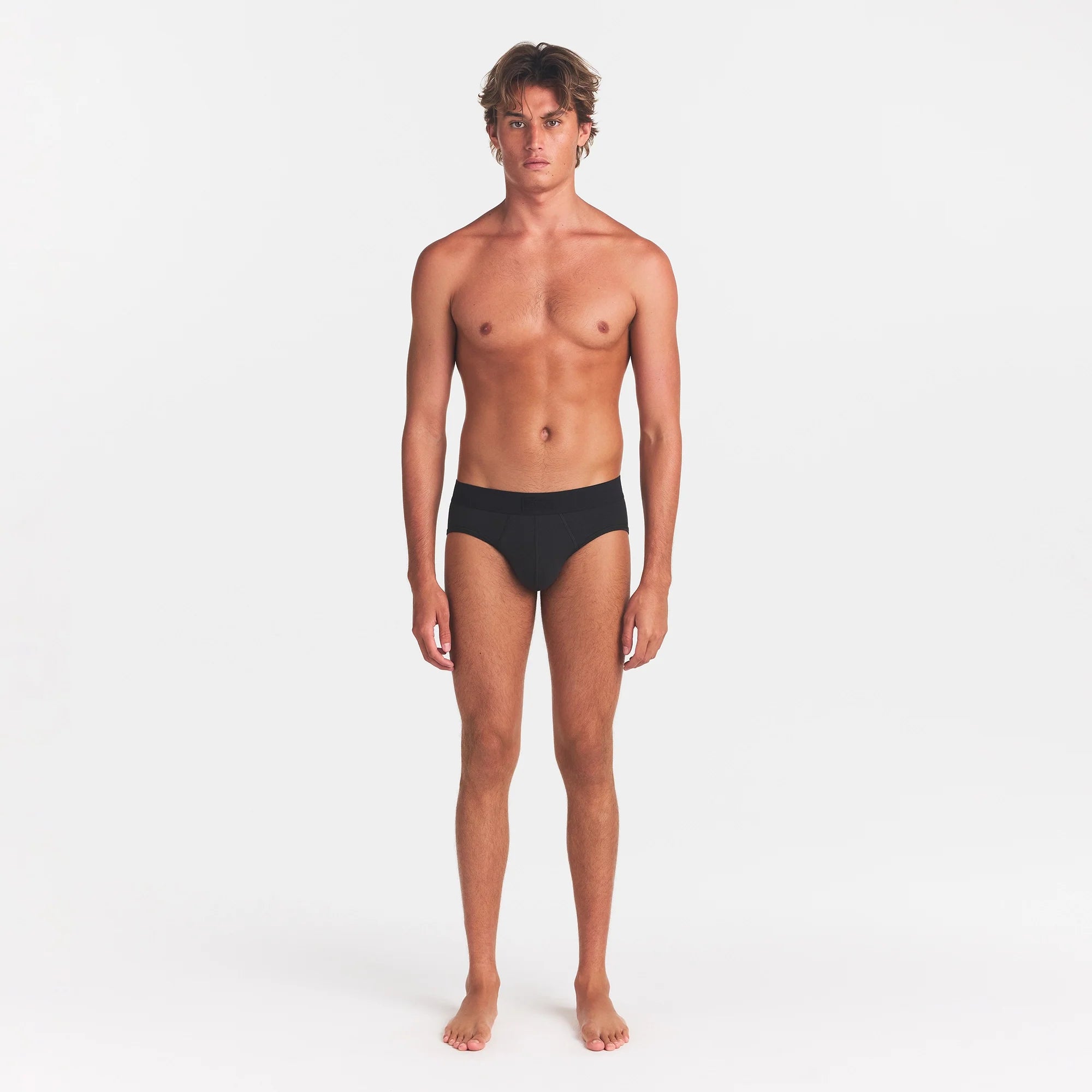 SKIMS COTTON MENS BRIEF | ONYX ON A MODEL FRONT VIEW