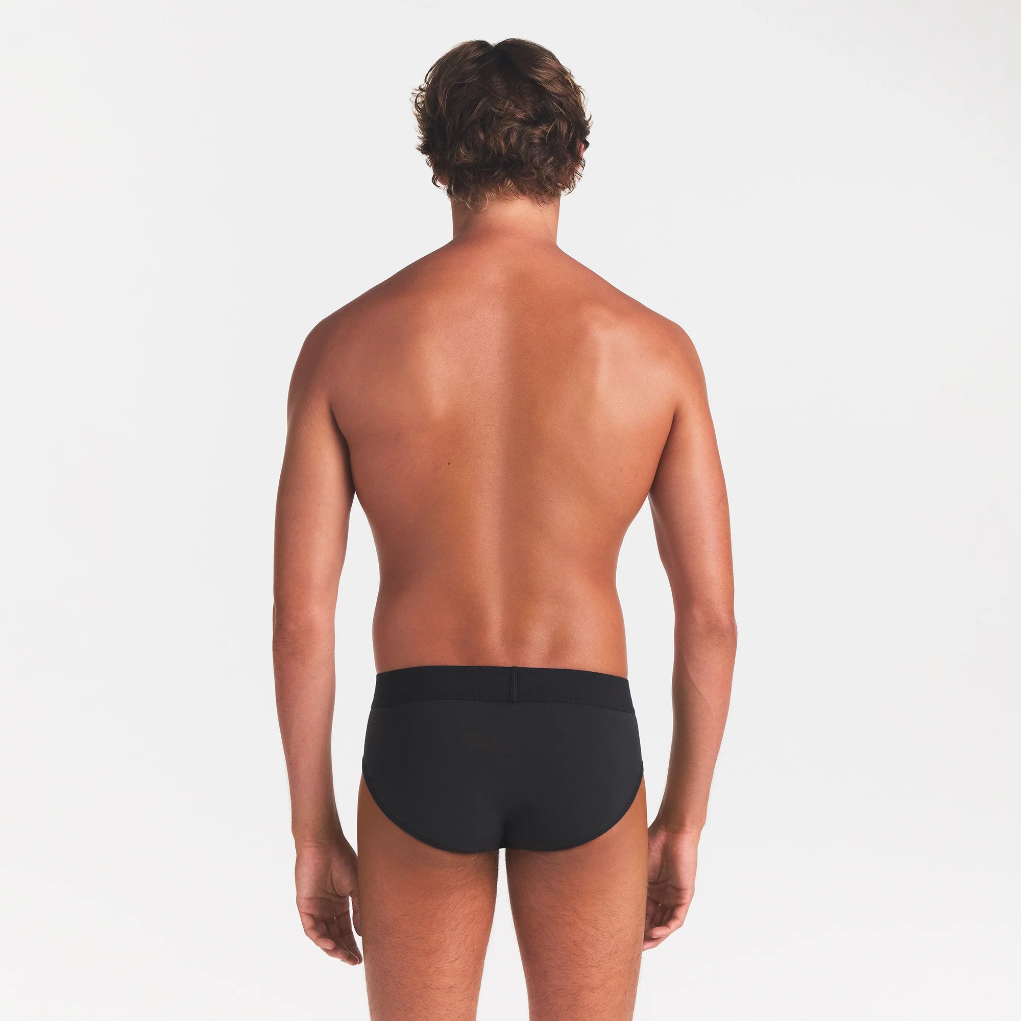 SKIMS COTTON MENS BRIEF | ONYX ON A MODEL BACK VIEW