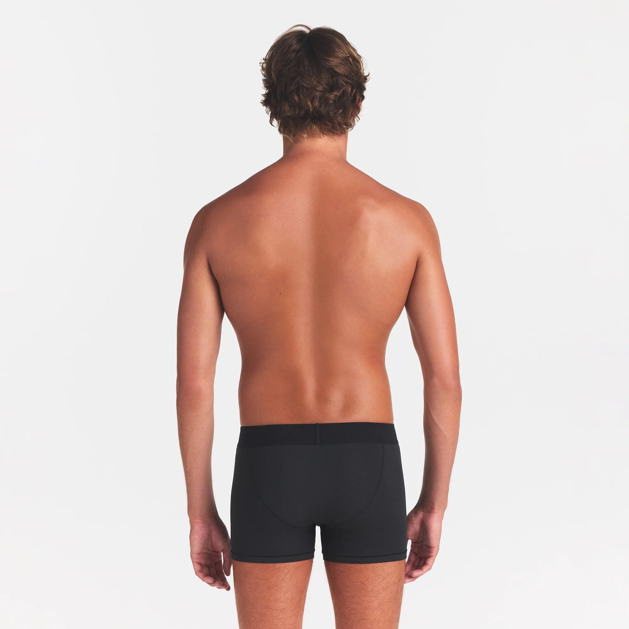 SKIMS COTTON MENS 3" BOXER BRIEF | ONYX ON A MODEL BACK VIEW