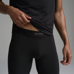 SKIMS SPORT MENS LEGGING | OBSIDIAN ON A MODEL SIDE VIEW | FOCUS: 0.0, 1.0, 0.9