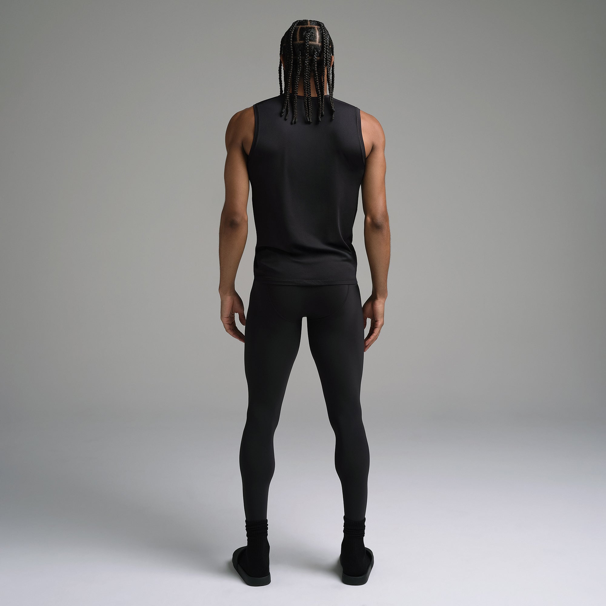 SKIMS SPORT MENS LEGGING | OBSIDIAN ON A MODEL SIDE VIEW | FOCUS: 0.0, 1.0, 0.9