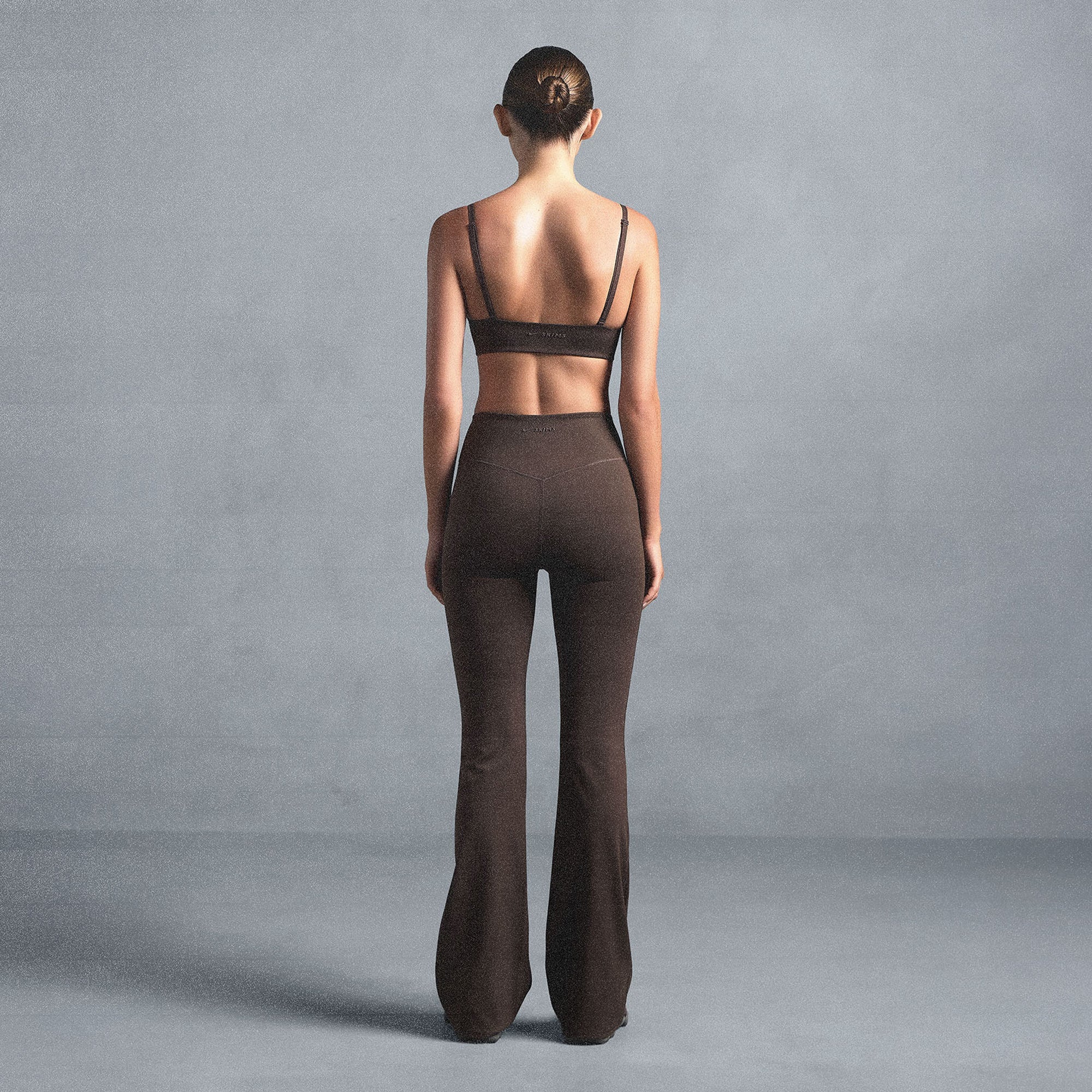 NikeSKIMS MATTE SLIM FLARE LEGGING | DARK SEPIA ON A MODEL SIDE VIEW @ | FOCUS: 0.0, 1.0, 0.9