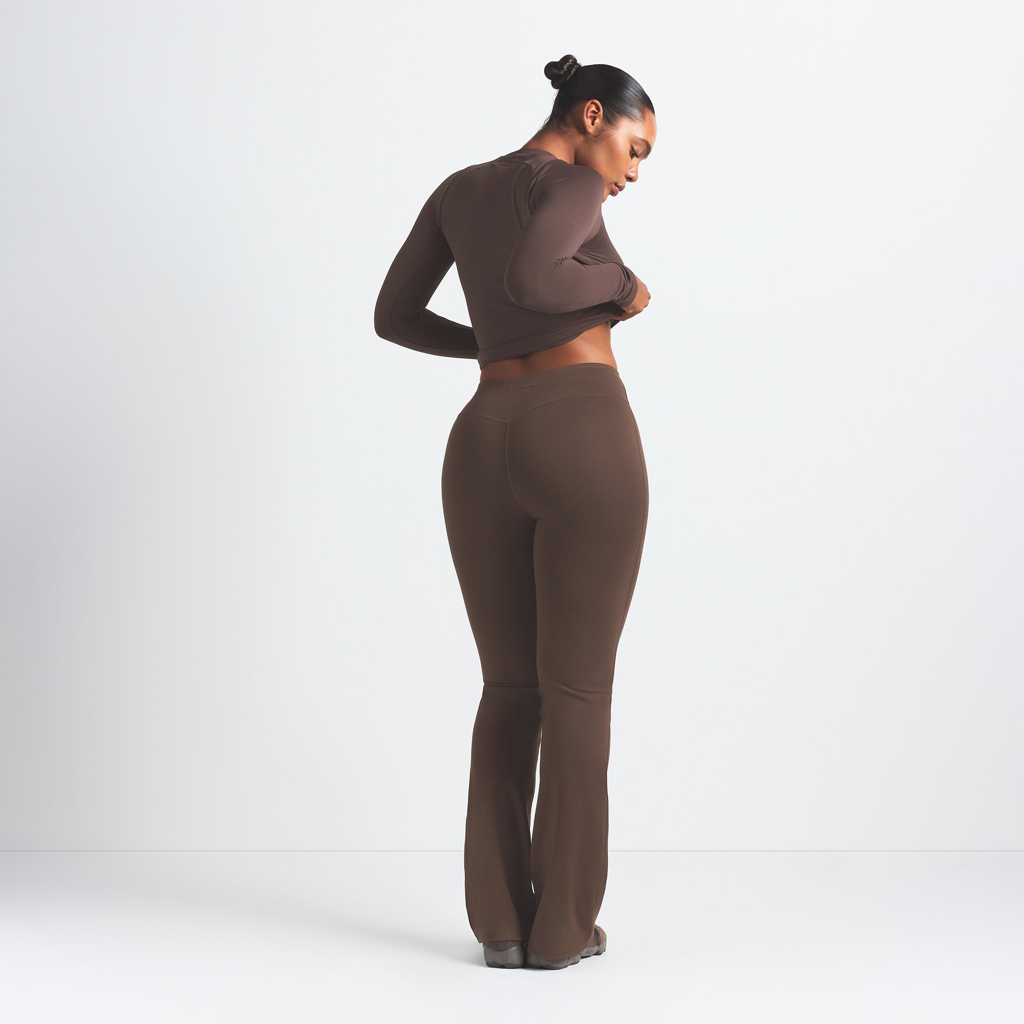 NikeSKIMS MATTE SLIM FLARE LEGGING | DARK SEPIA ON A MODEL BACK VIEW