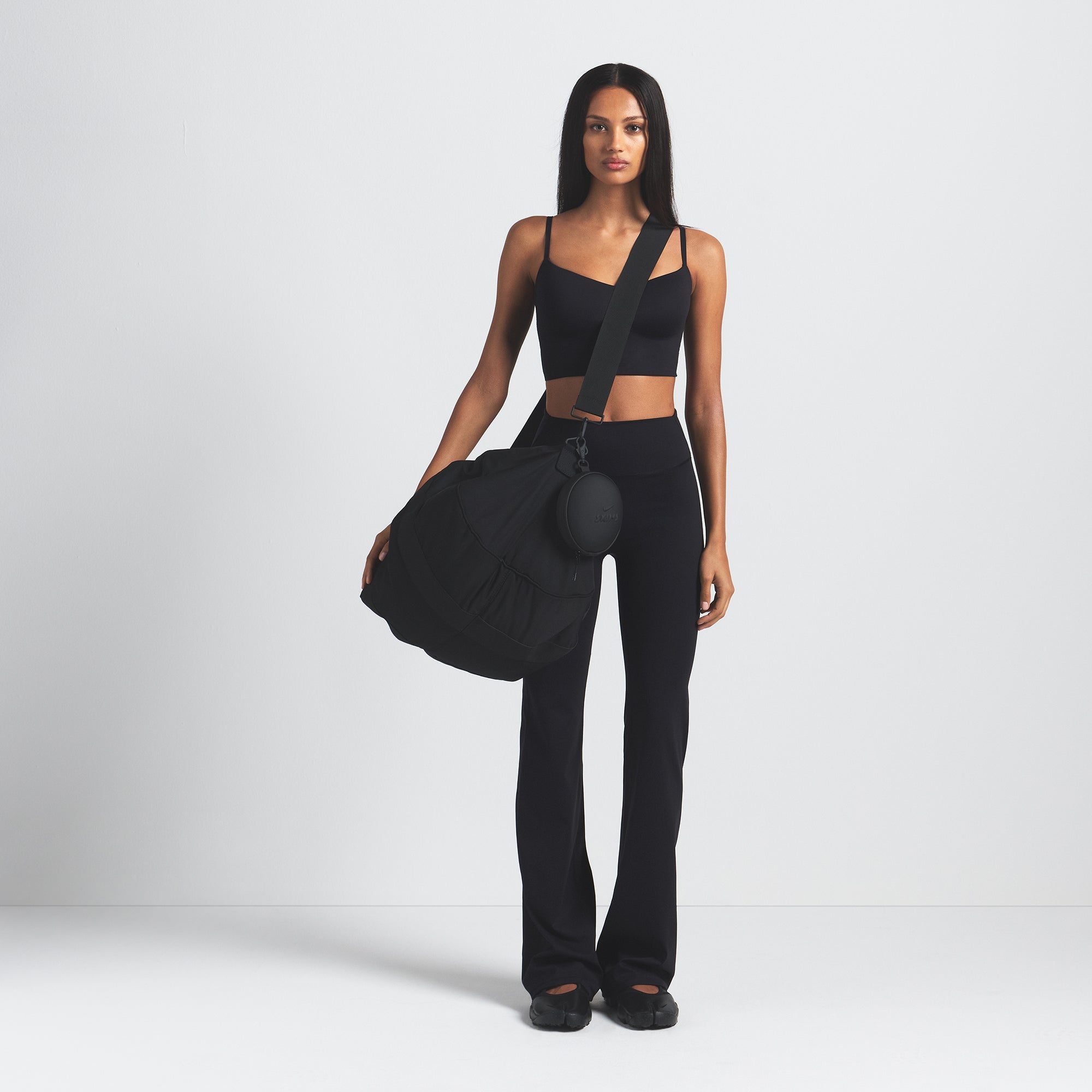 NikeSKIMS MATTE SLIM FLARE LEGGING | OBSIDIAN ON A MODEL FRONT VIEW @ | FOCUS: 0.0, 1.0, 0.9