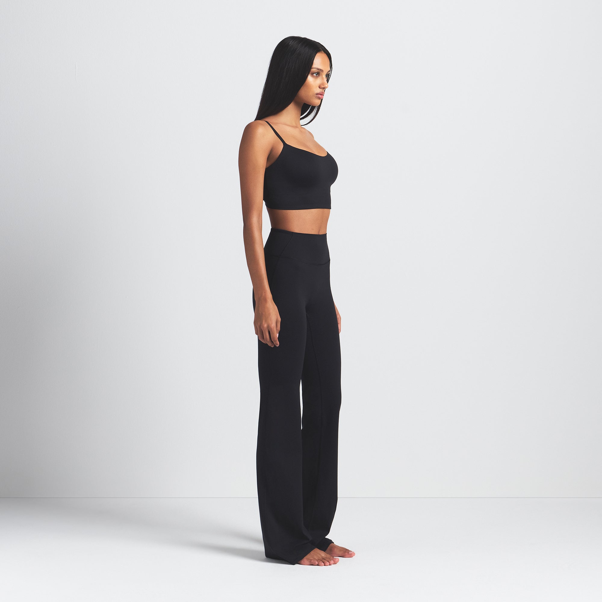 NikeSKIMS MATTE SLIM FLARE LEGGING | OBSIDIAN ON A MODEL SIDE VIEW @ | FOCUS: 0.0, 1.0, 0.9