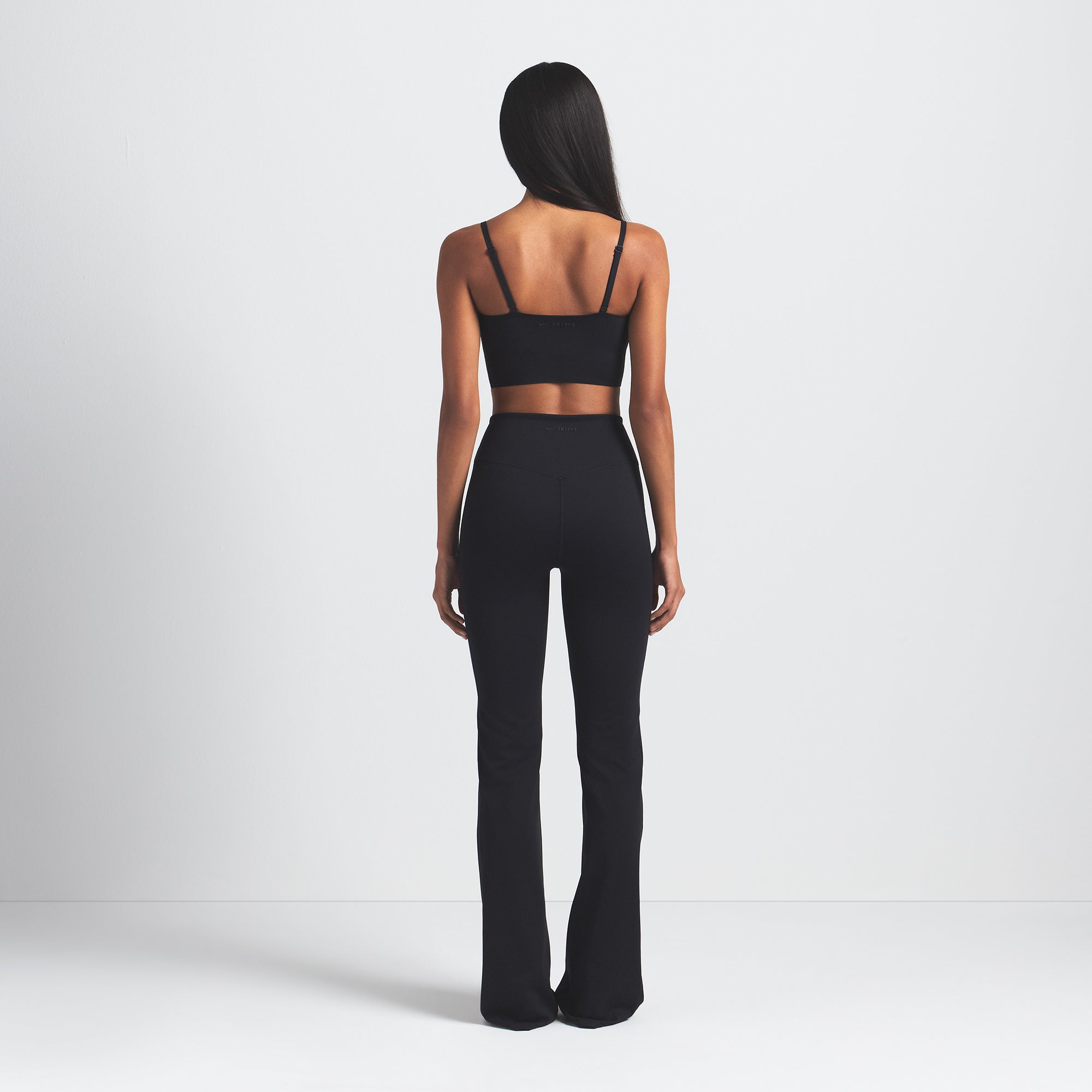 NikeSKIMS MATTE SLIM FLARE LEGGING | OBSIDIAN ON A MODEL BACK VIEW @ | FOCUS: 0.0, 1.0, 0.9
