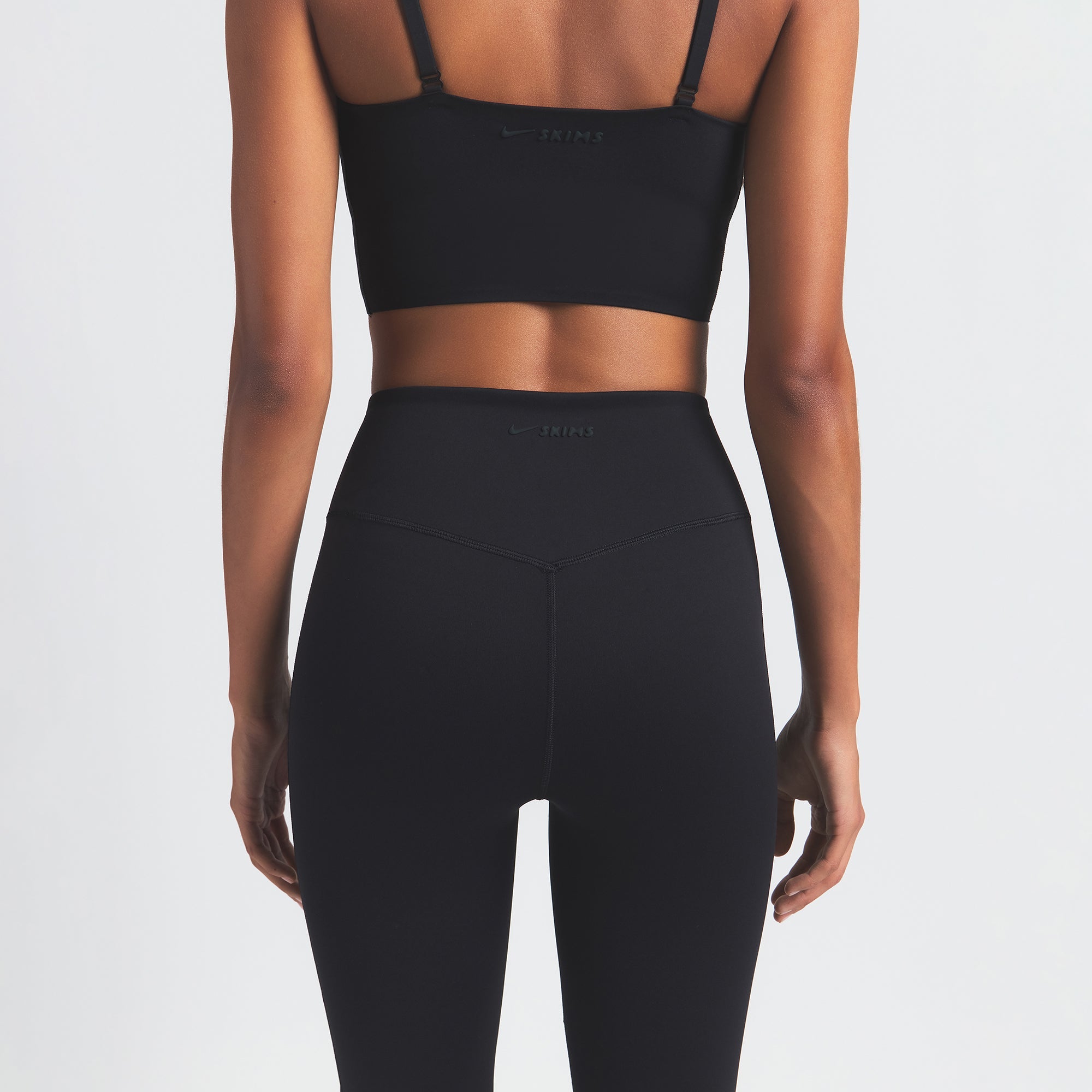 NikeSKIMS MATTE SLIM FLARE LEGGING | OBSIDIAN ON A MODEL BACK VIEW @ | FOCUS: 0.0, 1.0, 0.9