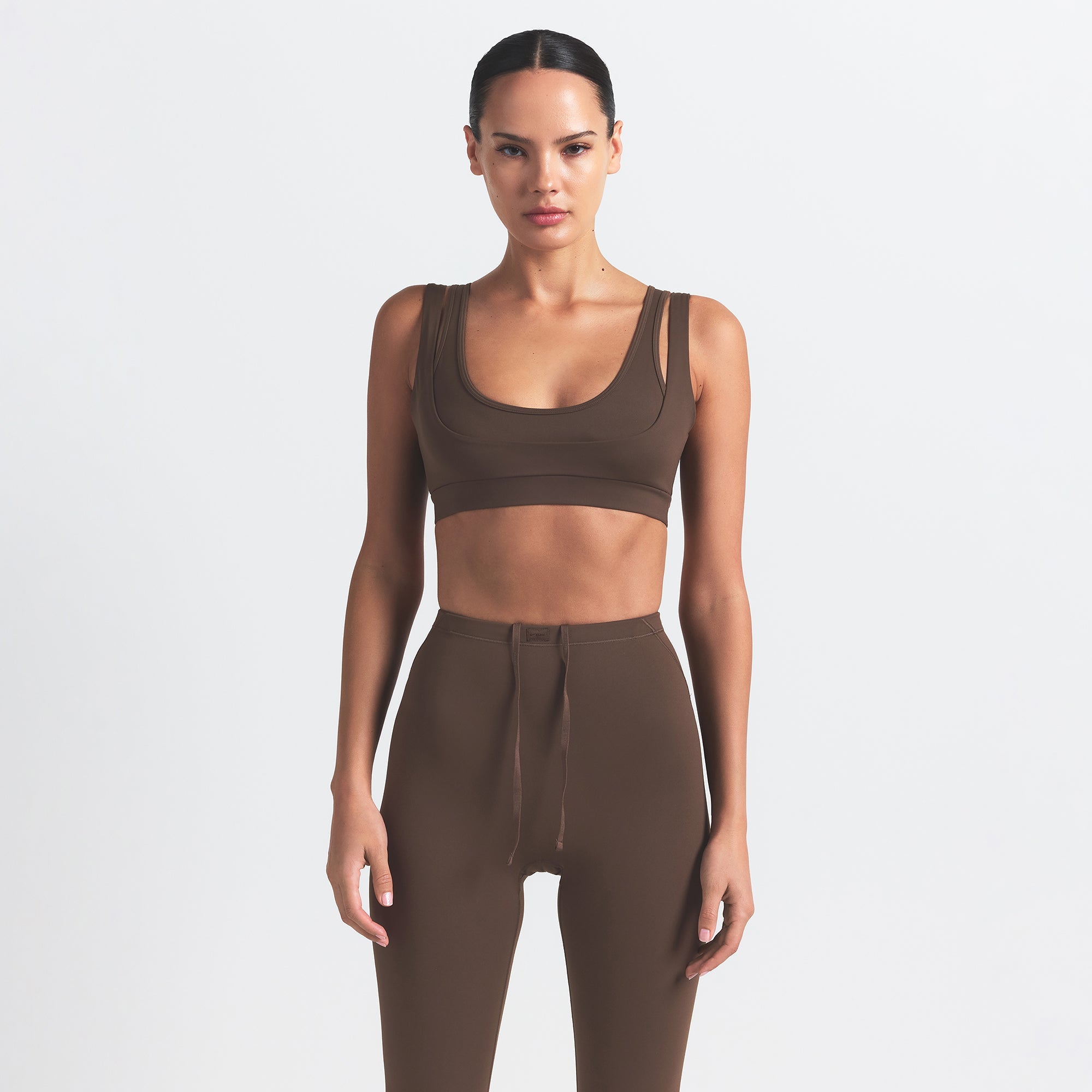 NikeSKIMS MATTE FOOTSIE GRIP LEGGING | DARK SEPIA ON A MODEL FRONT VIEW
