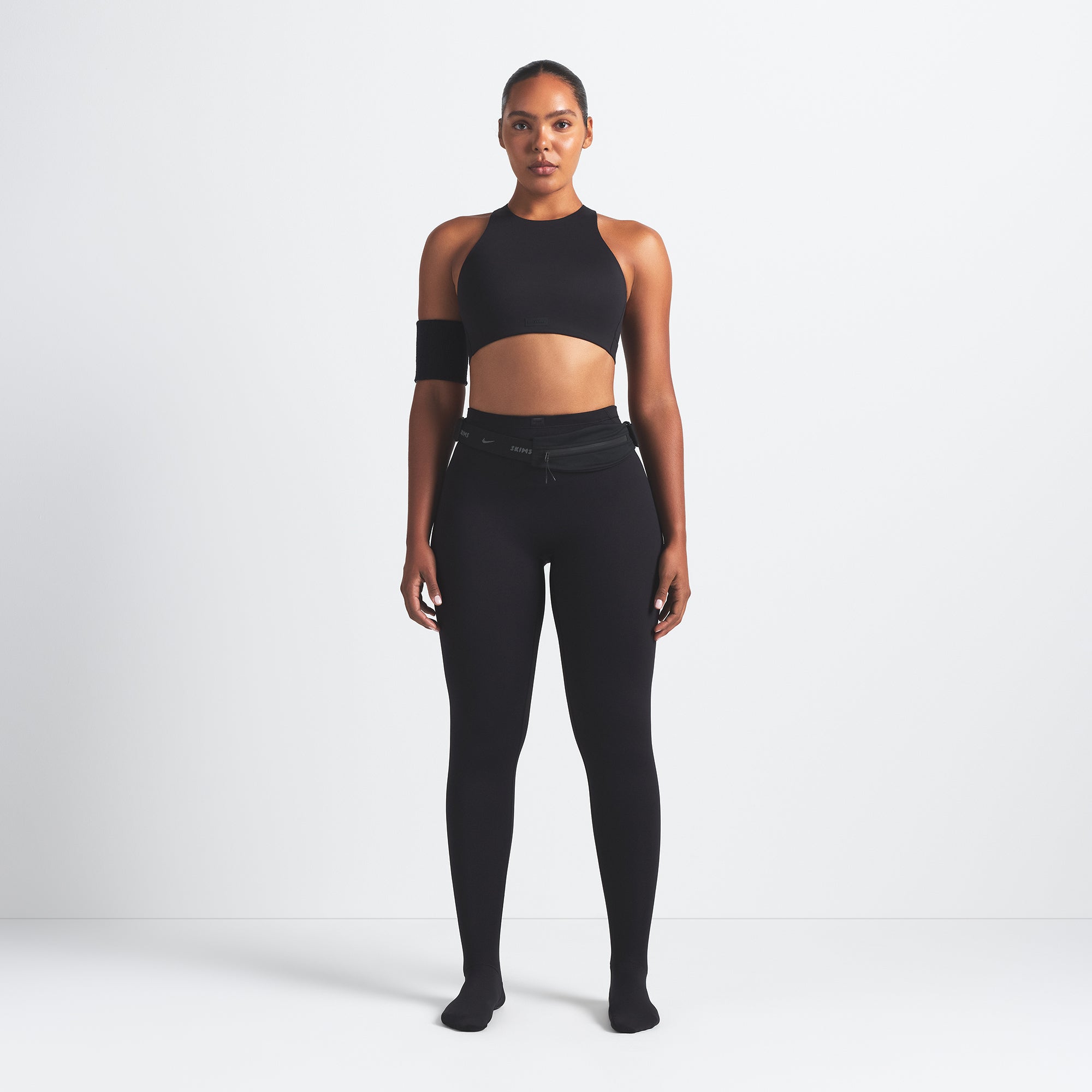 NikeSKIMS MATTE FOOTSIE GRIP LEGGING | OBSIDIAN ON A MODEL FRONT VIEW @ | FOCUS: 0.0, 1.0, 0.9
