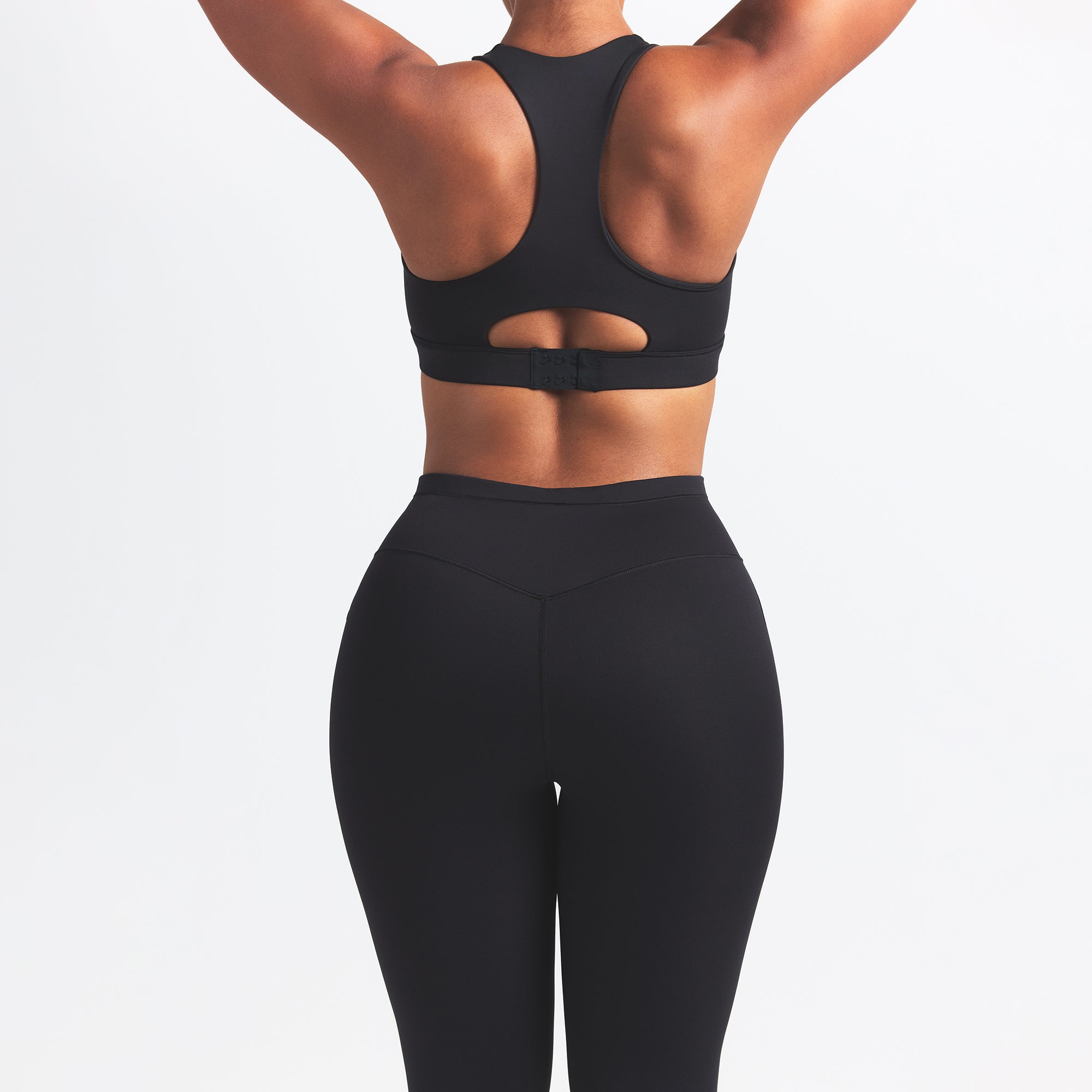 NikeSKIMS MATTE FOOTSIE GRIP LEGGING | OBSIDIAN ON A MODEL BACK VIEW @ | FOCUS: 0.0, 1.0, 0.9