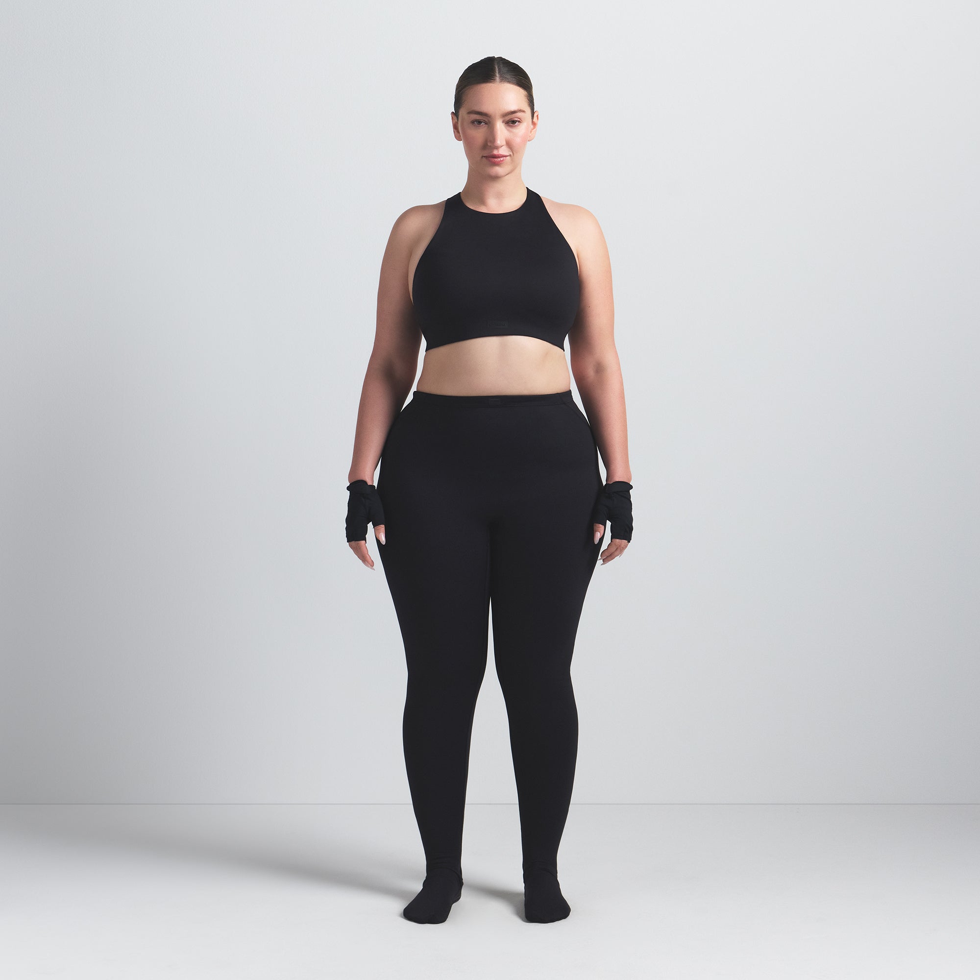 NikeSKIMS MATTE FOOTSIE GRIP LEGGING | OBSIDIAN ON A MODEL FRONT VIEW @ | FOCUS: 0.0, 1.0, 0.9