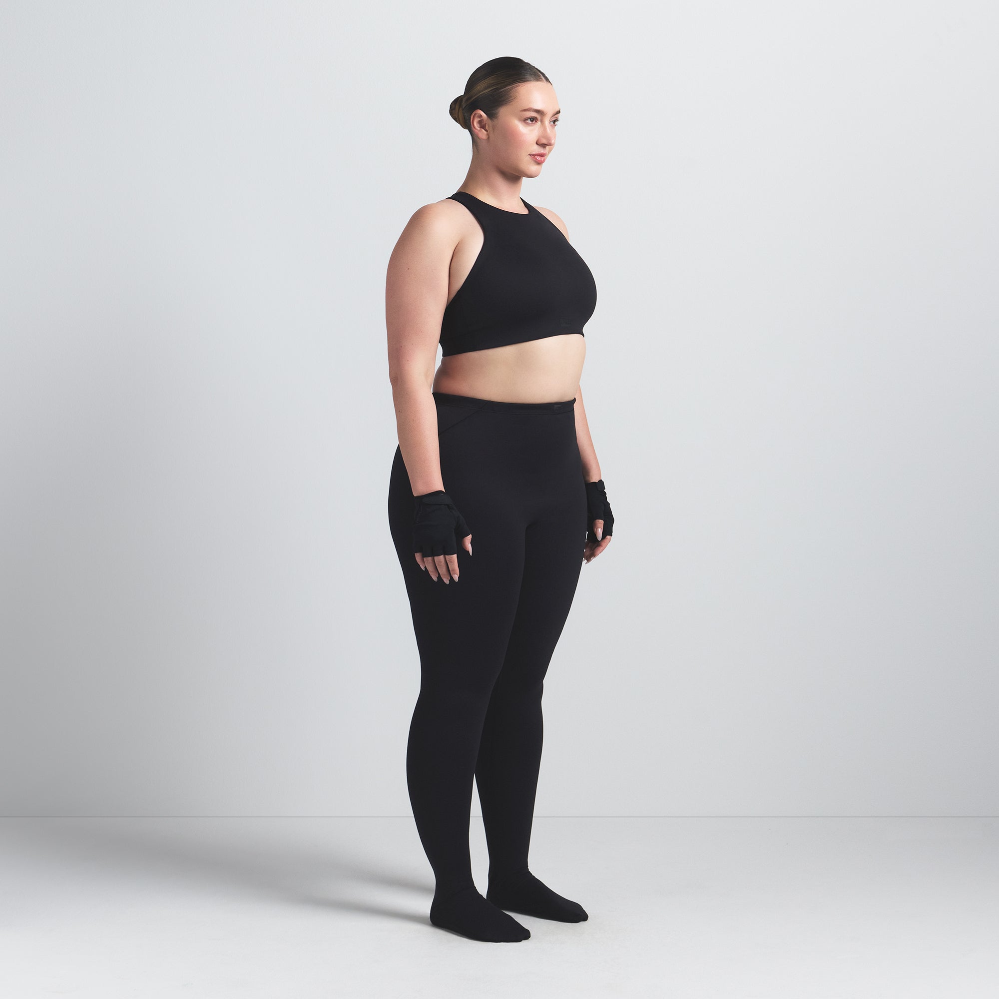 NikeSKIMS MATTE FOOTSIE GRIP LEGGING | OBSIDIAN ON A MODEL SIDE VIEW @ | FOCUS: 0.0, 1.0, 0.9