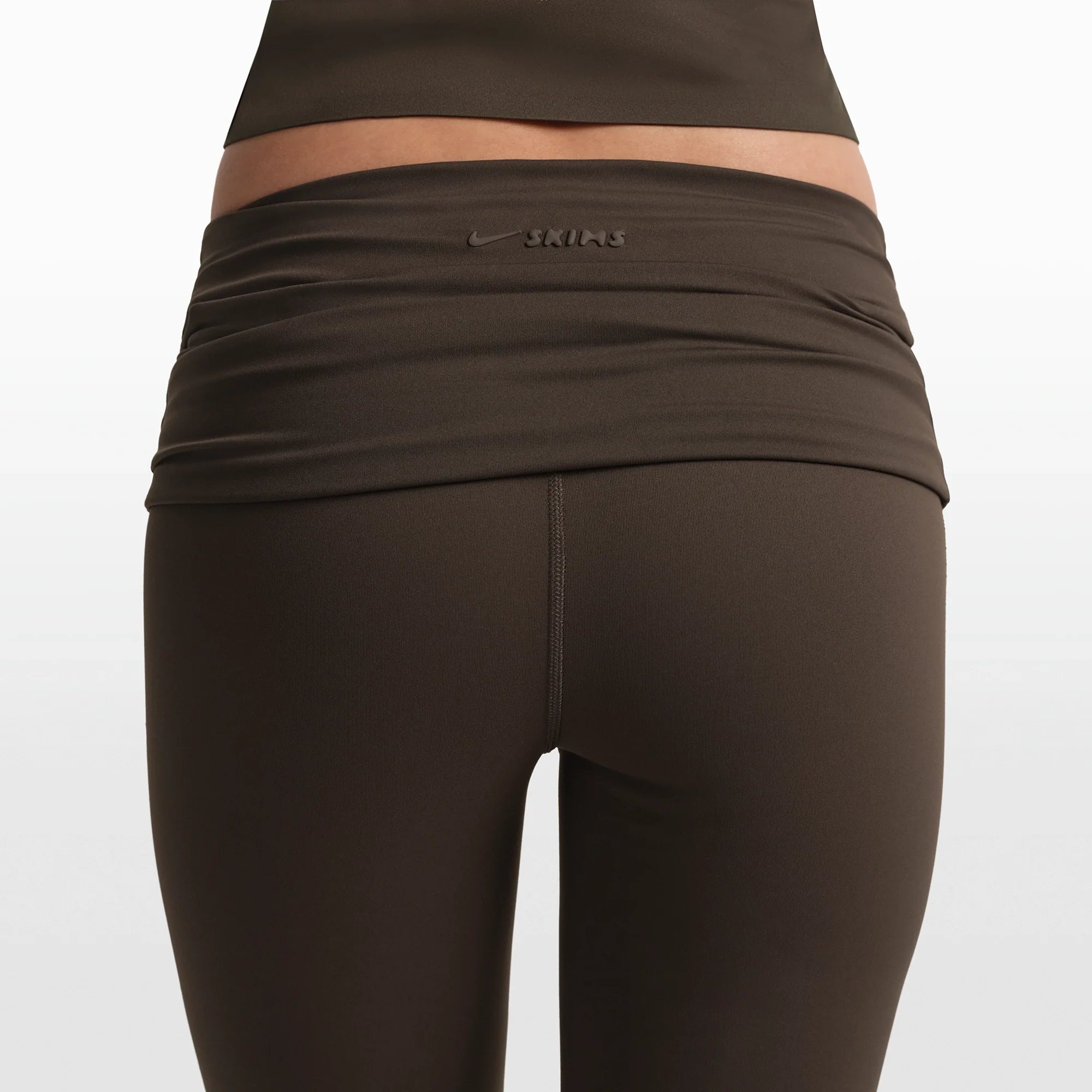 NikeSKIMS MATTE FOLDOVER SLIM FLARE LEGGING | DARK SEPIA ON A MODEL FRONT VIEW @ | FOCUS: 0.0, 1.0, 0.9