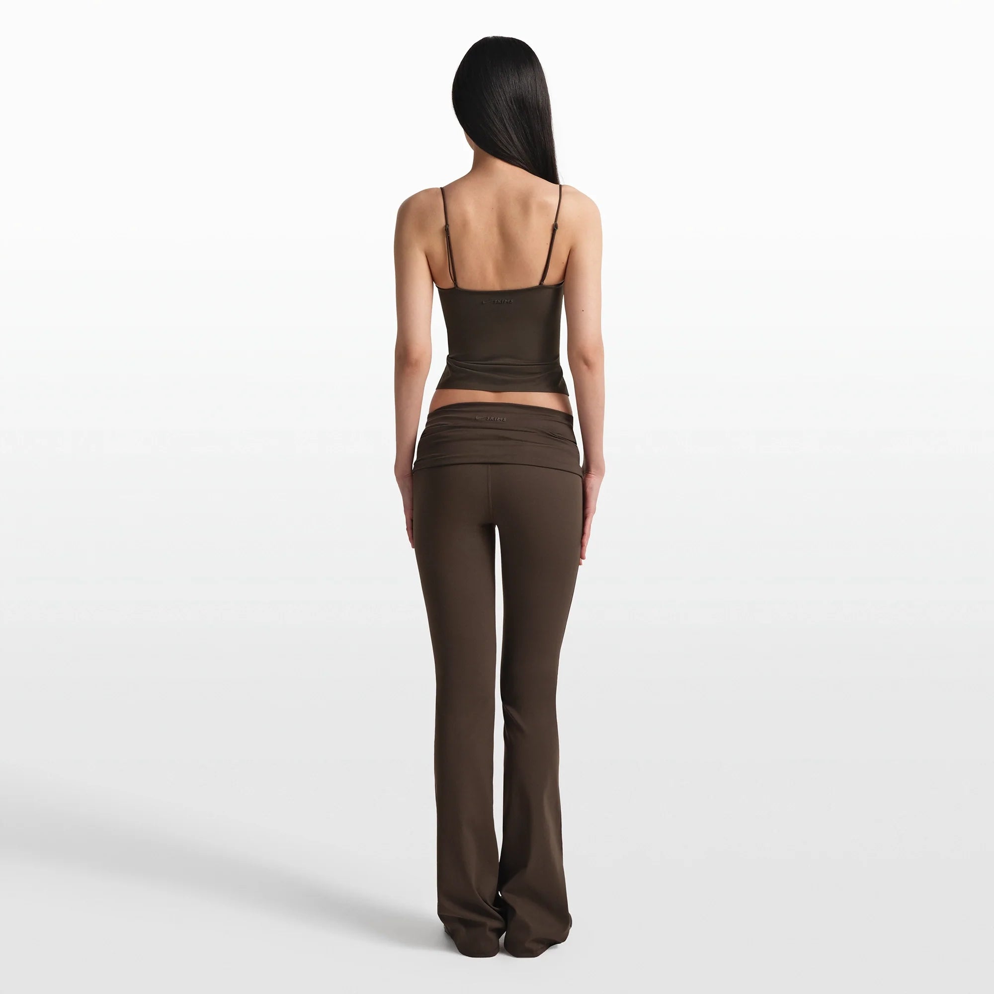NikeSKIMS MATTE FOLDOVER SLIM FLARE LEGGING | DARK SEPIA ON A MODEL FRONT VIEW @ | FOCUS: 0.0, 1.0, 0.9