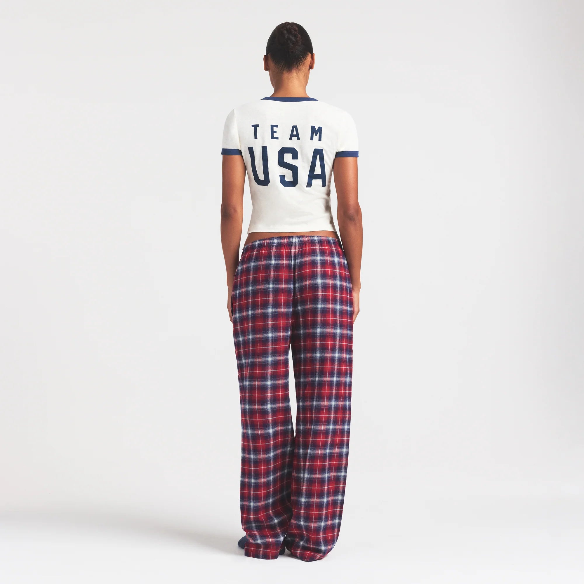 SKIMS FOR TEAM USA FLANNEL SLEEP OLYMPIC PANT | RED PLAID ON A MODEL FRONT VIEW @ | FOCUS: 0.0, 1.0, 0.9