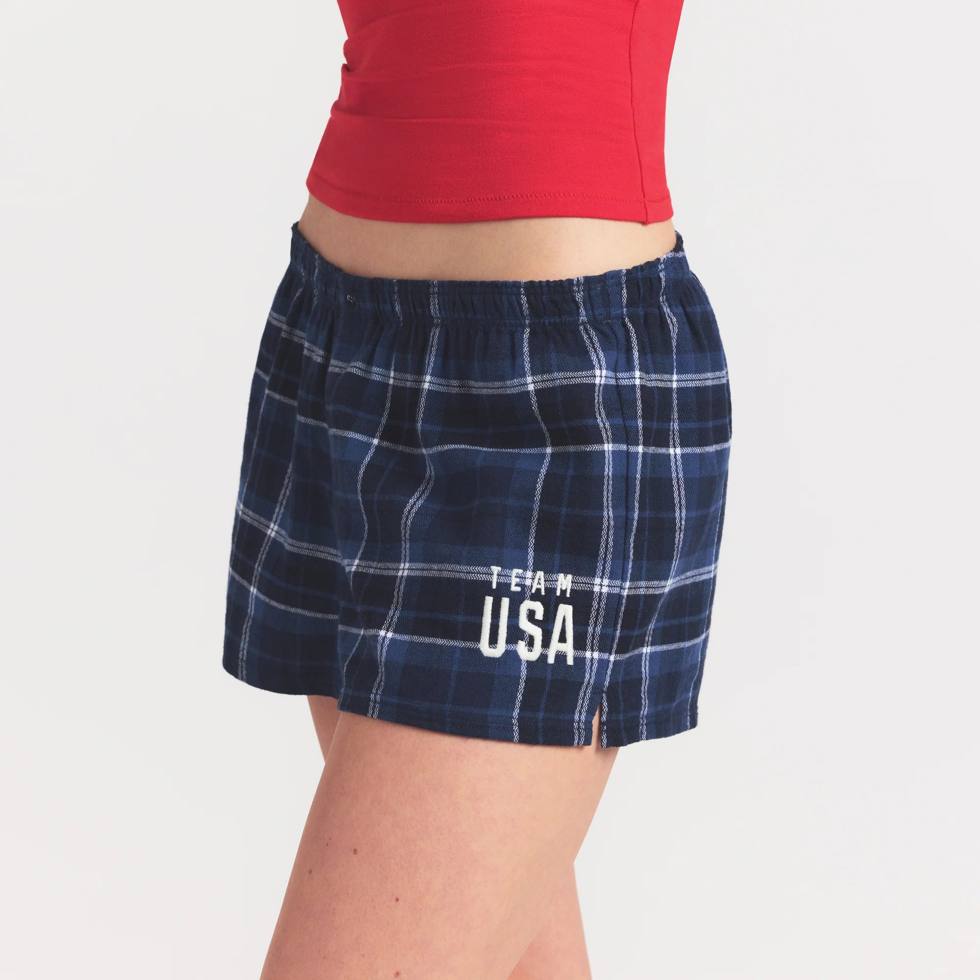 SKIMS FOR TEAM USA FLANNEL SLEEP OLYMPIC SHORT | NAVY PLAID ON A MODEL SIDE VIEW @ | FOCUS: 0.0, 1.0, 0.9