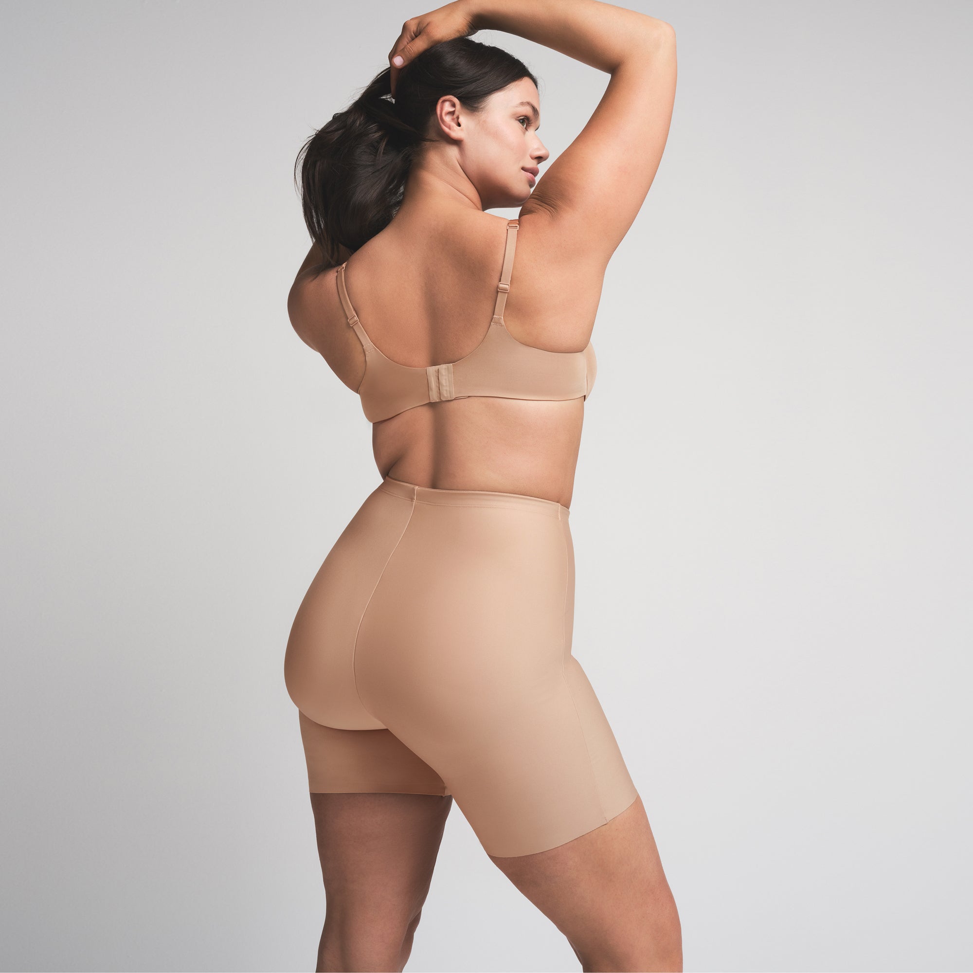 SKIMS BODY BUTT ENHANCING PADDED SHORT | CLAY  ON A MODEL SIDE VIEW