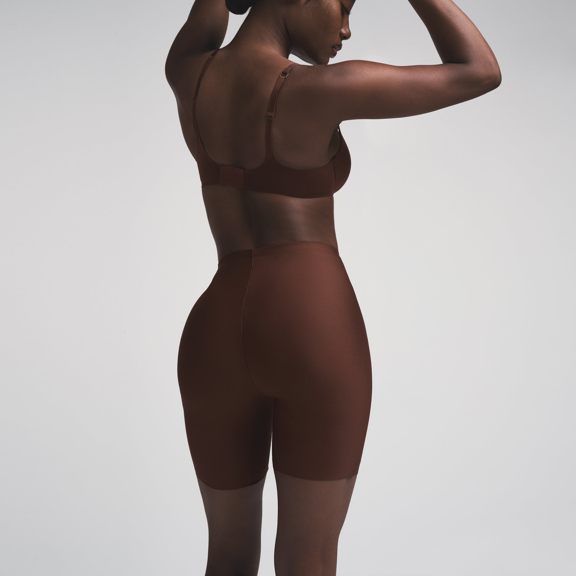 SKIMS BODY BUTT ENHANCING PADDED SHORT | COCOA ON A MODEL SIDE VIEW