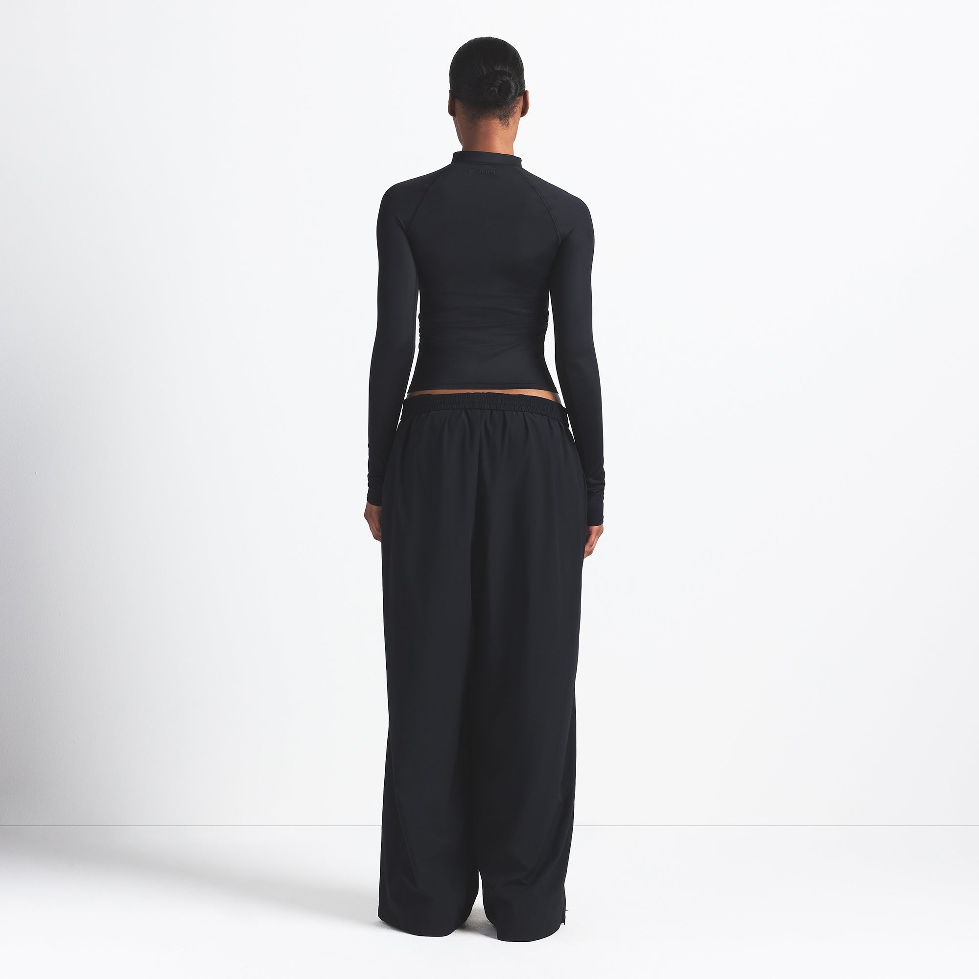NikeSKIMS WOVEN NYLON OVERSIZED TRACK PANT | OBSIDIAN ON A MODEL BACK VIEW @ | FOCUS: 0.0, 1.0, 0.9