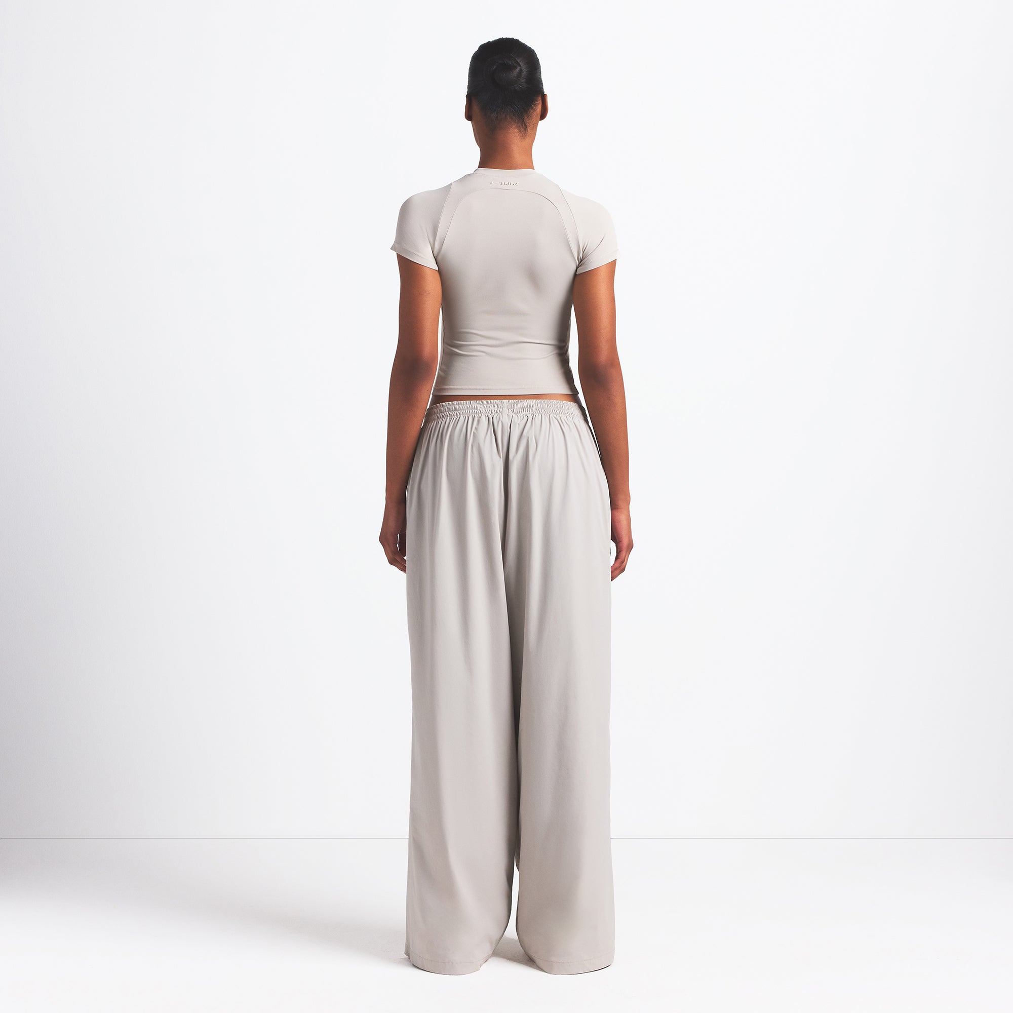 NikeSKIMS WOVEN NYLON OVERSIZED TRACK PANT | STONE ON A MODEL BACK VIEW @ | FOCUS: 0.0, 1.0, 0.9