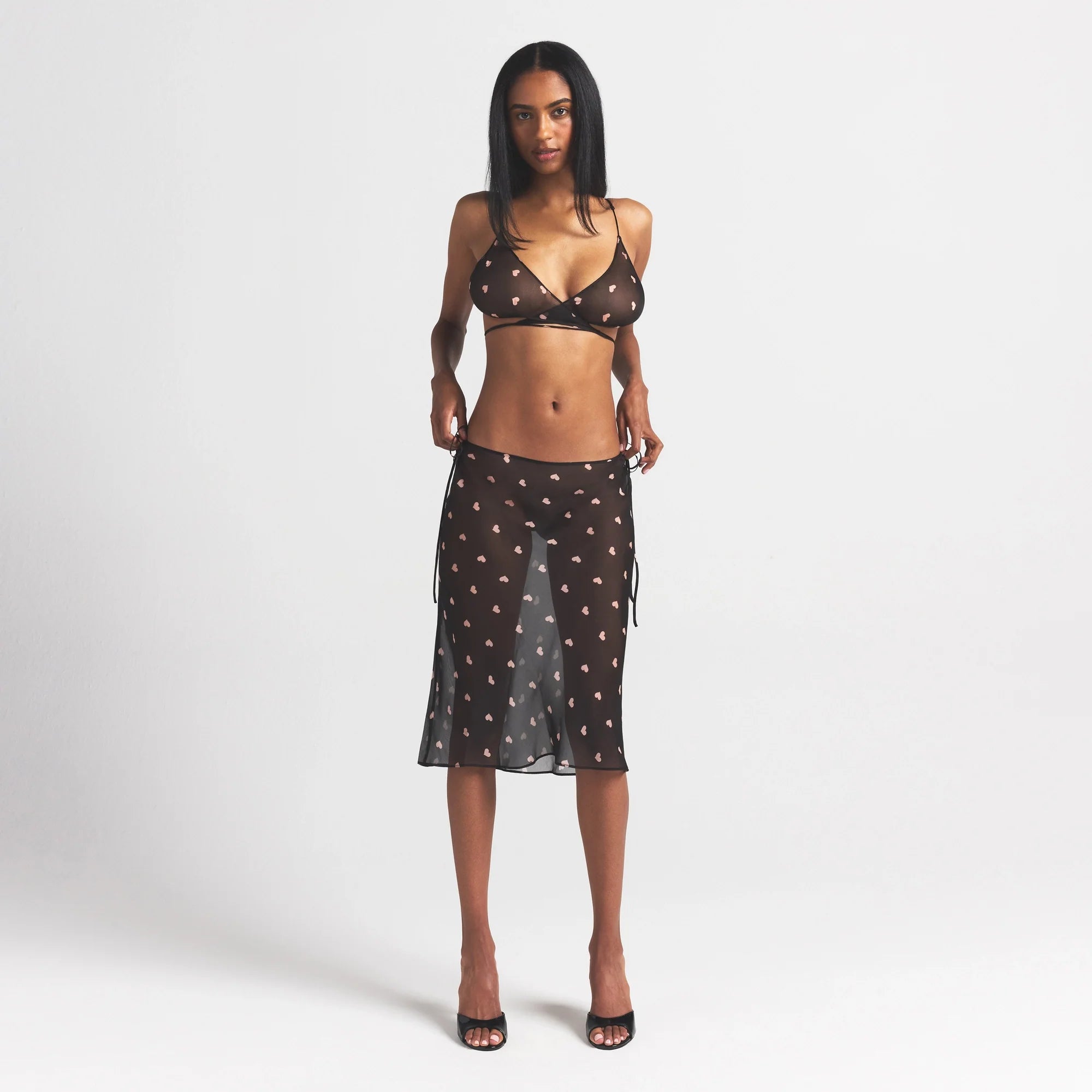 SKIMS ROMANCE SKIMPY WRAP BRALETTE | OBSIDIAN SPACED HEARTS ON A MODEL FRONT VIEW @ | FOCUS: 0.0, 1.0, 0.9