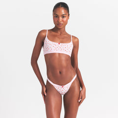 LIGHTWEIGHT COTTON LOGO PICOT SCOOP BRALETTE | BABY PINK ARROWED HEARTS ON A MODEL SIDE VIEW