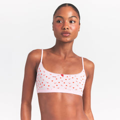 LIGHTWEIGHT COTTON LOGO PICOT SCOOP BRALETTE | BABY PINK ARROWED HEARTS ON A MODEL SIDE VIEW