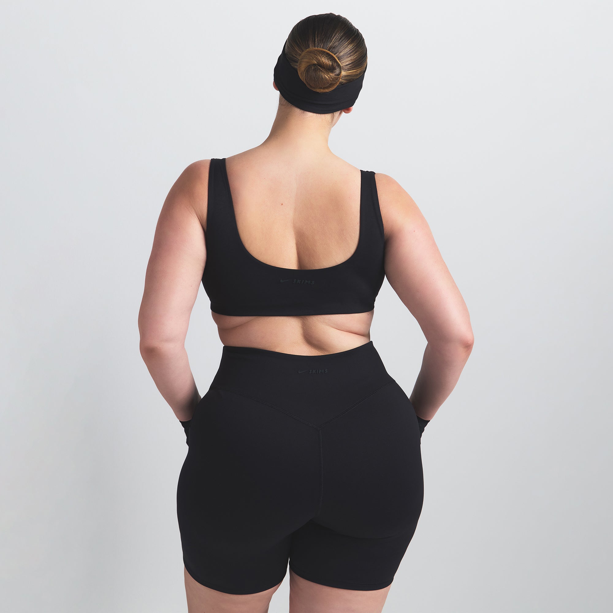 NikeSKIMS MATTE SCOOP NECK BRA | OBSIDIAN ON A MODEL BACK VIEW @ | FOCUS: 0.0, 1.0, 0.9