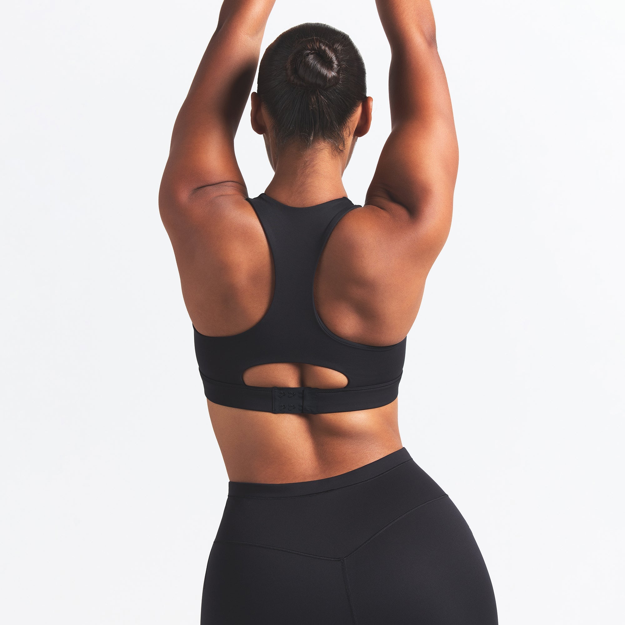 NikeSKIMS MATTE HIGH NECK BRA | OBSIDIAN ON A MODEL BACK VIEW @ | FOCUS: 0.0, 1.0, 0.9