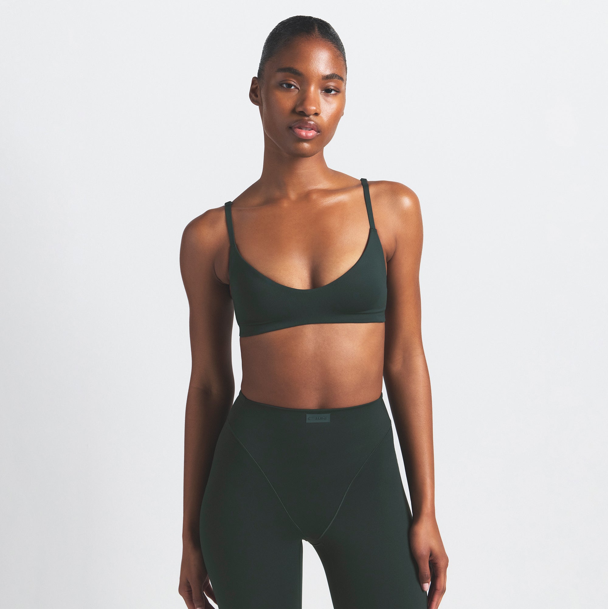 NikeSKIMS MATTE MICRO SCOOP BRA | DARK TEAL ON A MODEL SIDE VIEW @ | FOCUS: 0.0, 1.0, 0.9