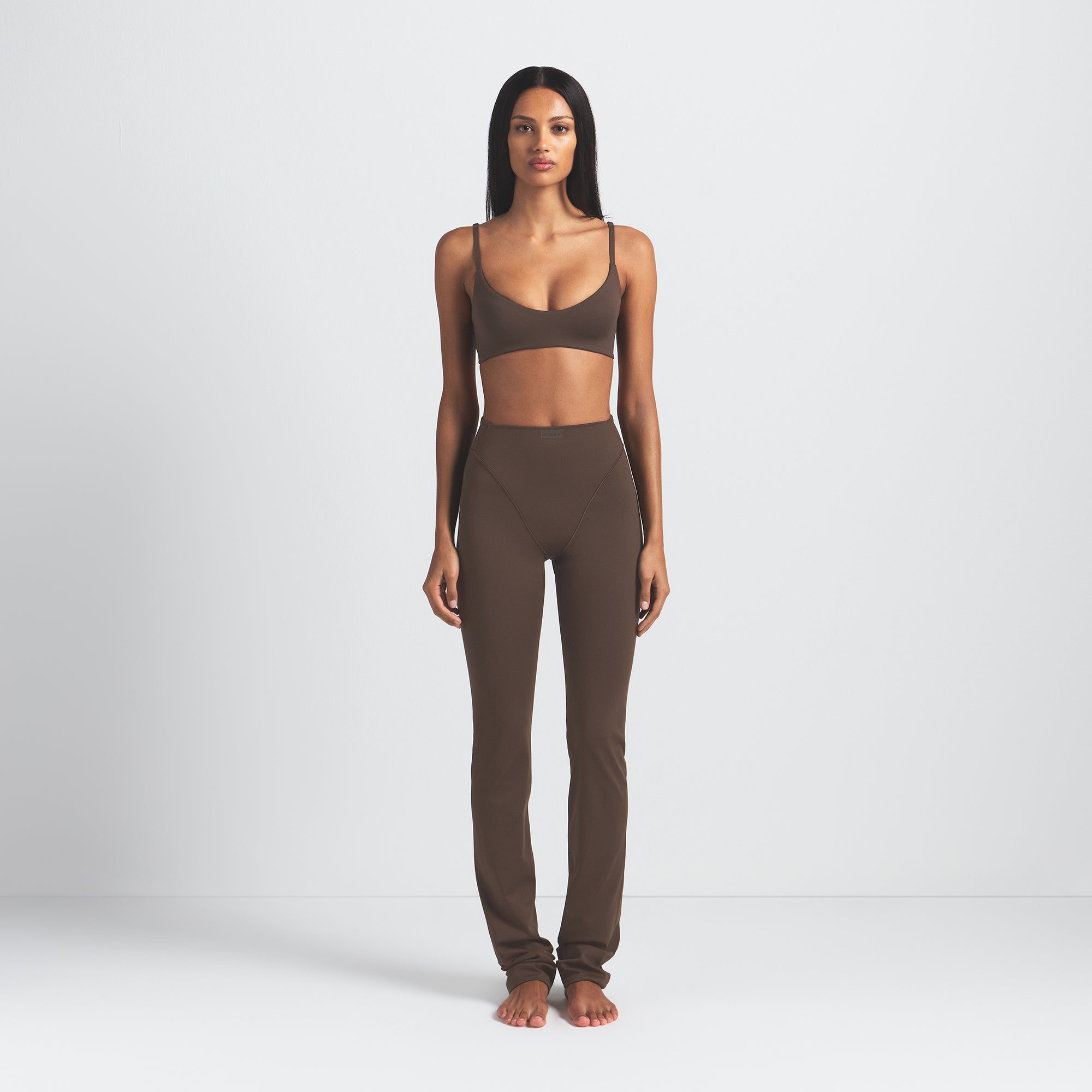 NikeSKIMS MATTE MICRO SCOOP BRA | DARK SEPIA ON A MODEL FRONT VIEW