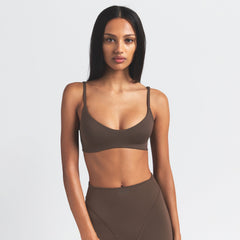 NikeSKIMS MATTE MICRO SCOOP BRA | DARK SEPIA ON A MODEL FRONT VIEW