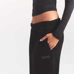 COTTON FLEECE STRAIGHT LEG PANT WITH EMBOSSED LOGO | ONYX ON A MODEL SIDE VIEW @ | FOCUS: 0.0, 1.0, 0.9