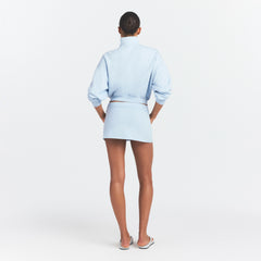 DRAPEY FRENCH TERRY MINI SKIRT | POWDER BLUE ON A MODEL SIDE VIEW @ | FOCUS: 0.0, 1.0, 0.9