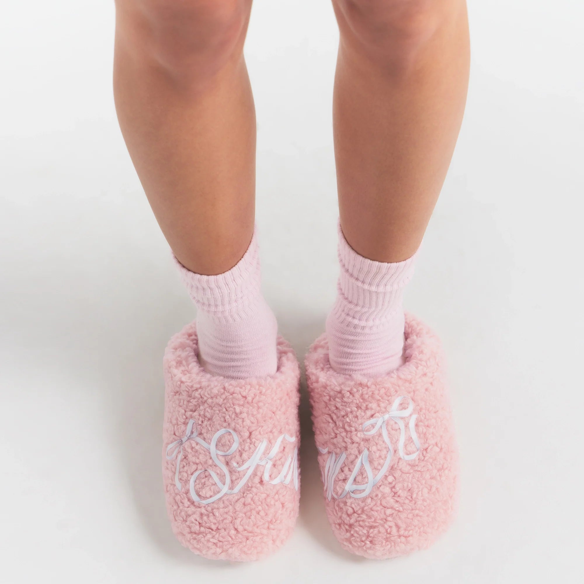 SKIMS ACCESSORIES SHERPA SLIPPER | PEONY SKIMS BOW ON A MODEL SIDE VIEW @ | FOCUS: 0.0, 1.0, 0.9