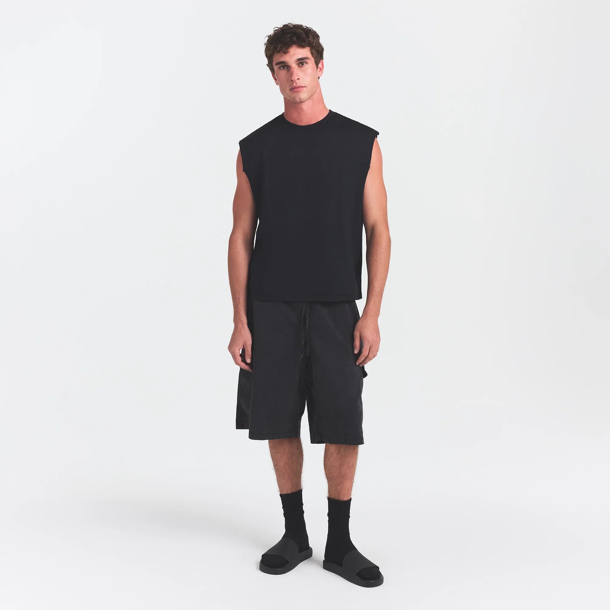 SKIMS ACCESSORIES MENS POOL SLIDE | ONYX ON A MODEL FRONT VIEW @ | FOCUS: 0.0, 1.0, 0.9