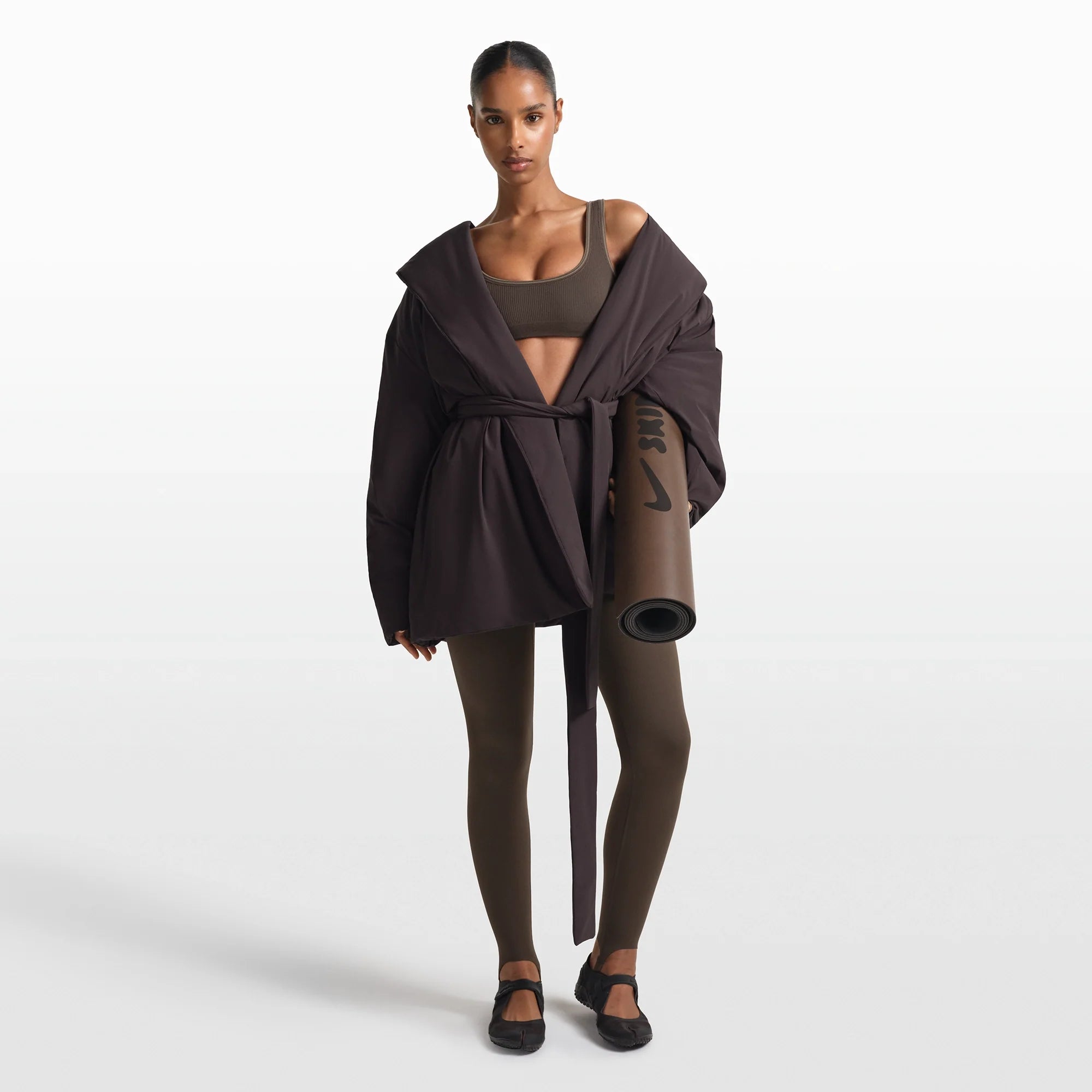 NikeSKIMS ACCESSORIES YOGA MAT | DARK SEPIA ON A MODEL FRONT VIEW @ | FOCUS: 0.0, 1.0, 0.9