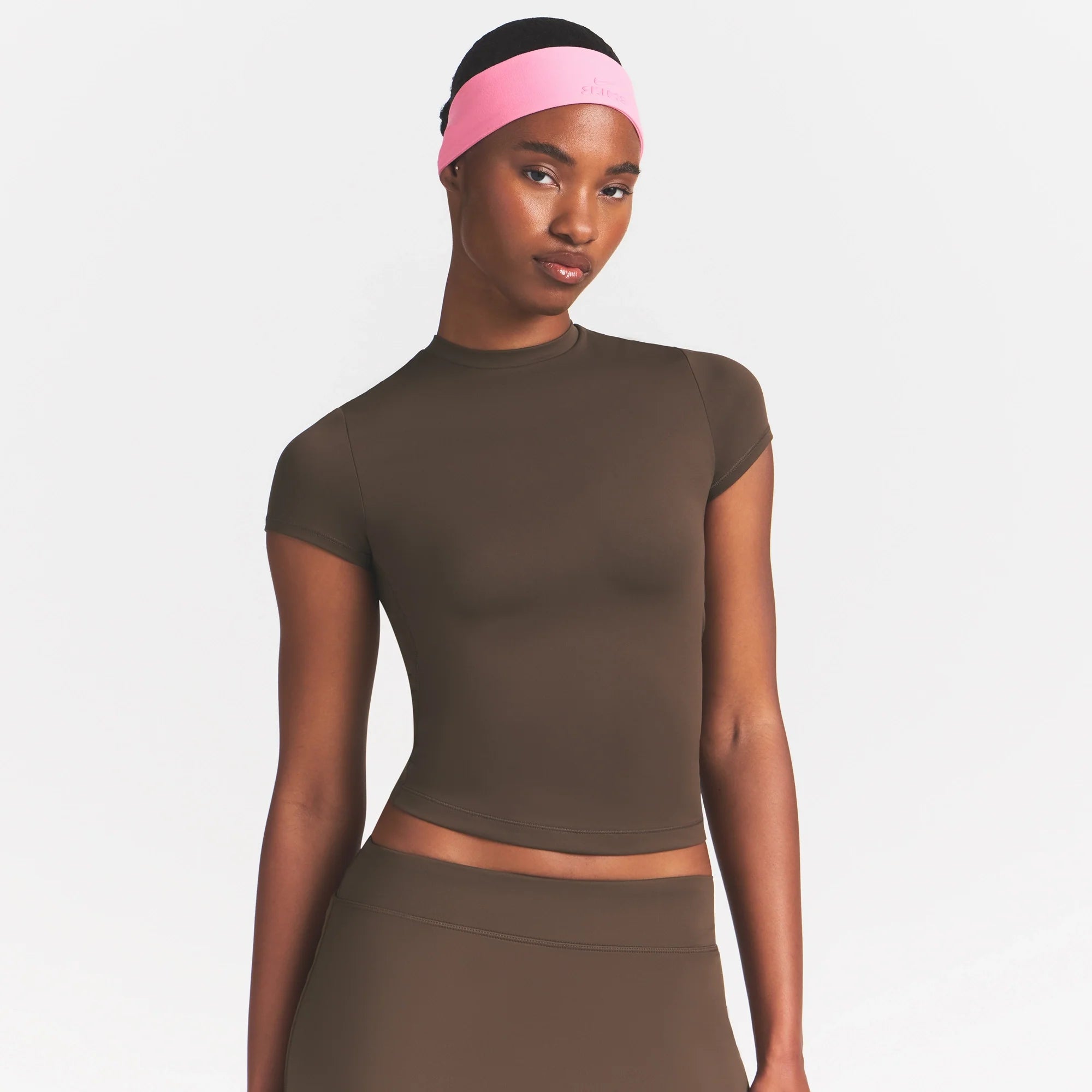 NikeSKIMS MATTE PADDED BABY TEE | DARK SEPIA ON A MODEL FRONT VIEW @ | FOCUS: 0.0, 1.0, 0.9